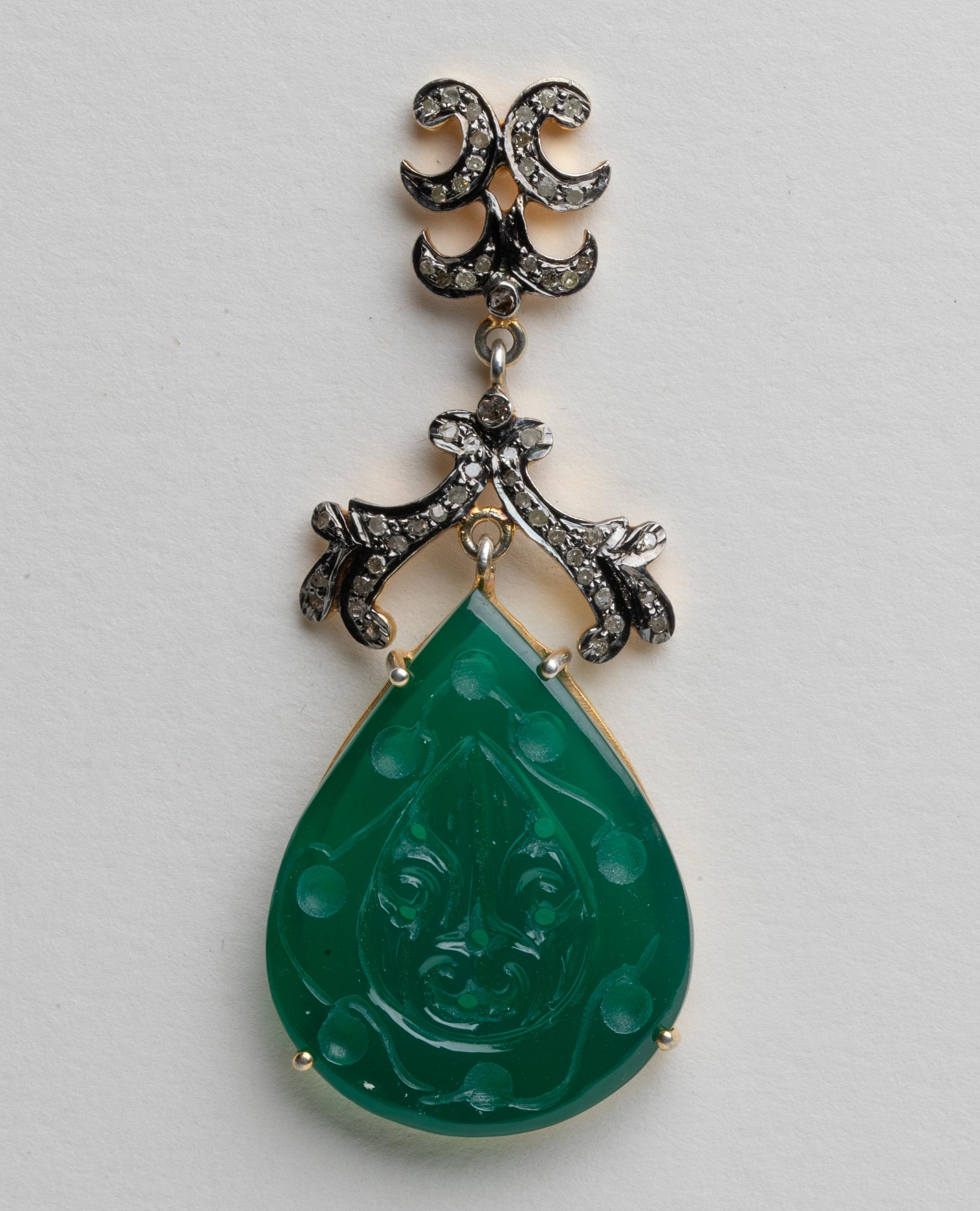 A striking pair of carved and pierced oval green chalcedony with pave`-set, round-cut diamonds above and at the top of the post.  Set in vermeil and post is 18K gold for pierced ears.  Diamond weight is .96 carats, green chalcedony is 39.40 carats.