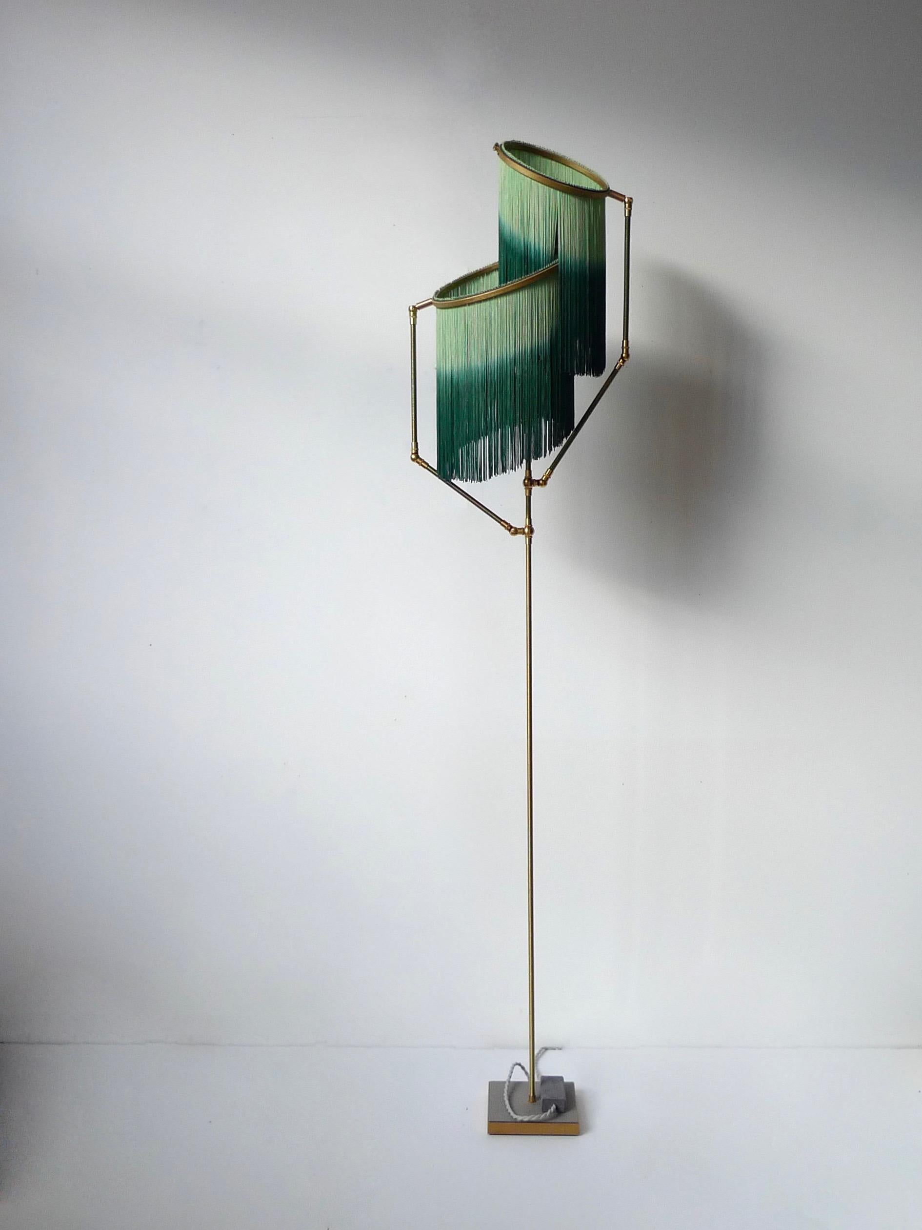 Green charme floor lamp, Sander Bottinga

Dimensions: H 153 x W 38 x D 25 cm

Handmade in brass, leather, wood and dip dyed colored Fringes in viscose.
The movable arms makes it possible to move the circles with fringes in different positions.
So