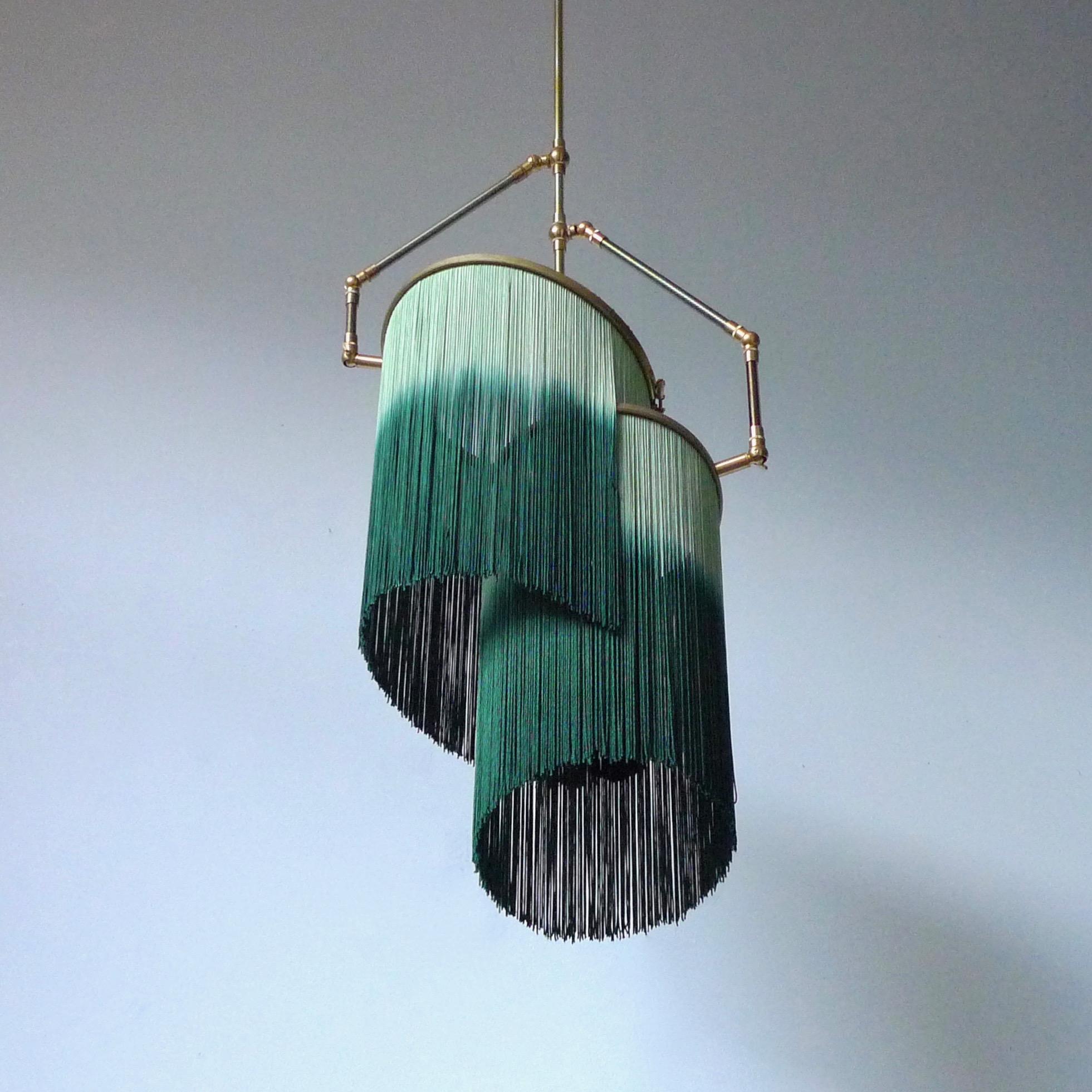 Green charme pendant lamp, Sander Bottinga

Dimensions: H 65 (can be customized) x W 38 x D 25 cm
Hand-Sculpted in brass, leather, wood and dip dyed colored Fringes in viscose.
The movable arms makes it possible to move the circles with fringes