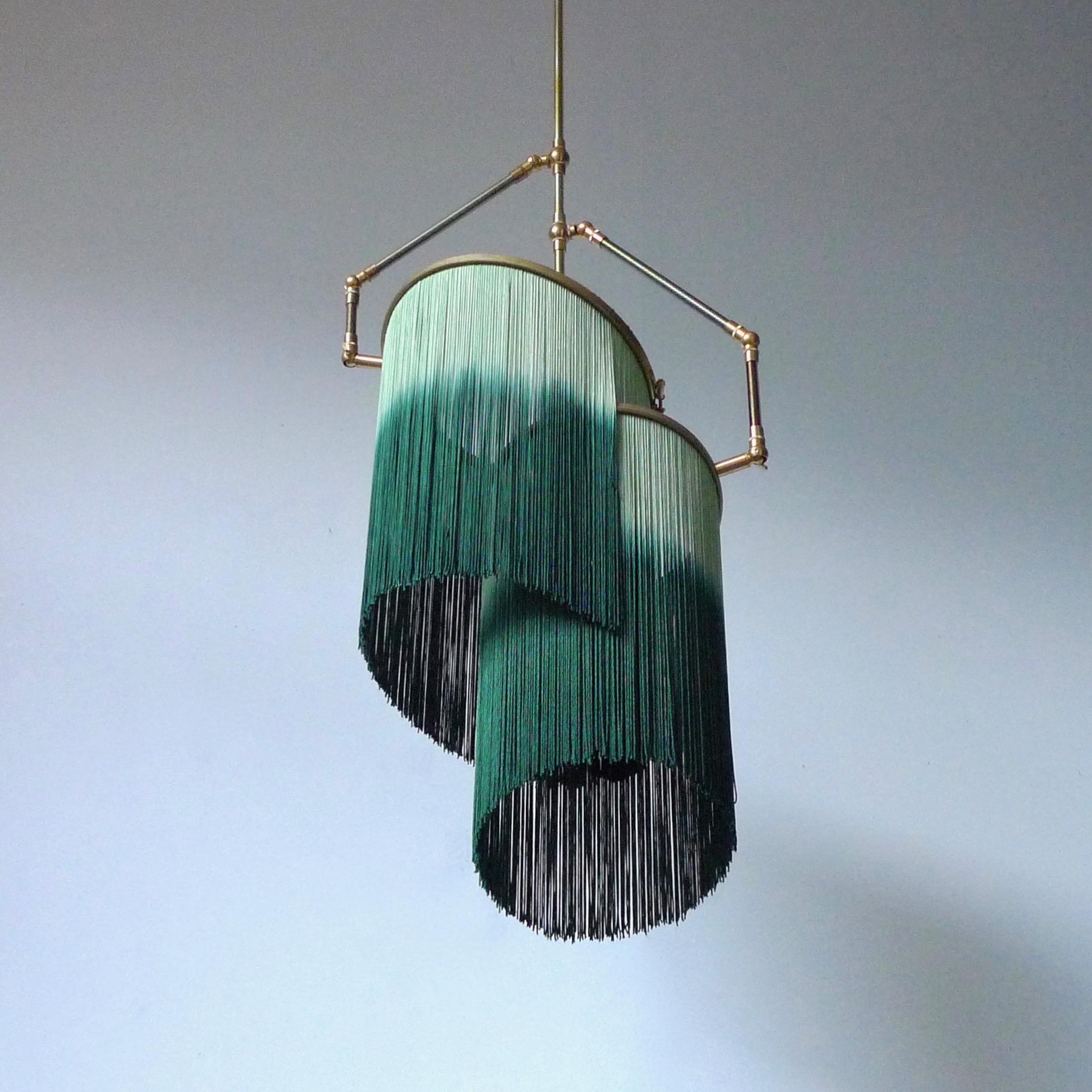 Lampe suspendue Green charme, Sander Bottinga.

Dimensions : H 65 (peut être personnalisé) x L 38 x P 25 cm : H 65 (peut être personnalisé) x L 38 x P 25 cm.
Sculptée à la main en laiton, cuir, bois et franges colorées en viscose.
Les bras