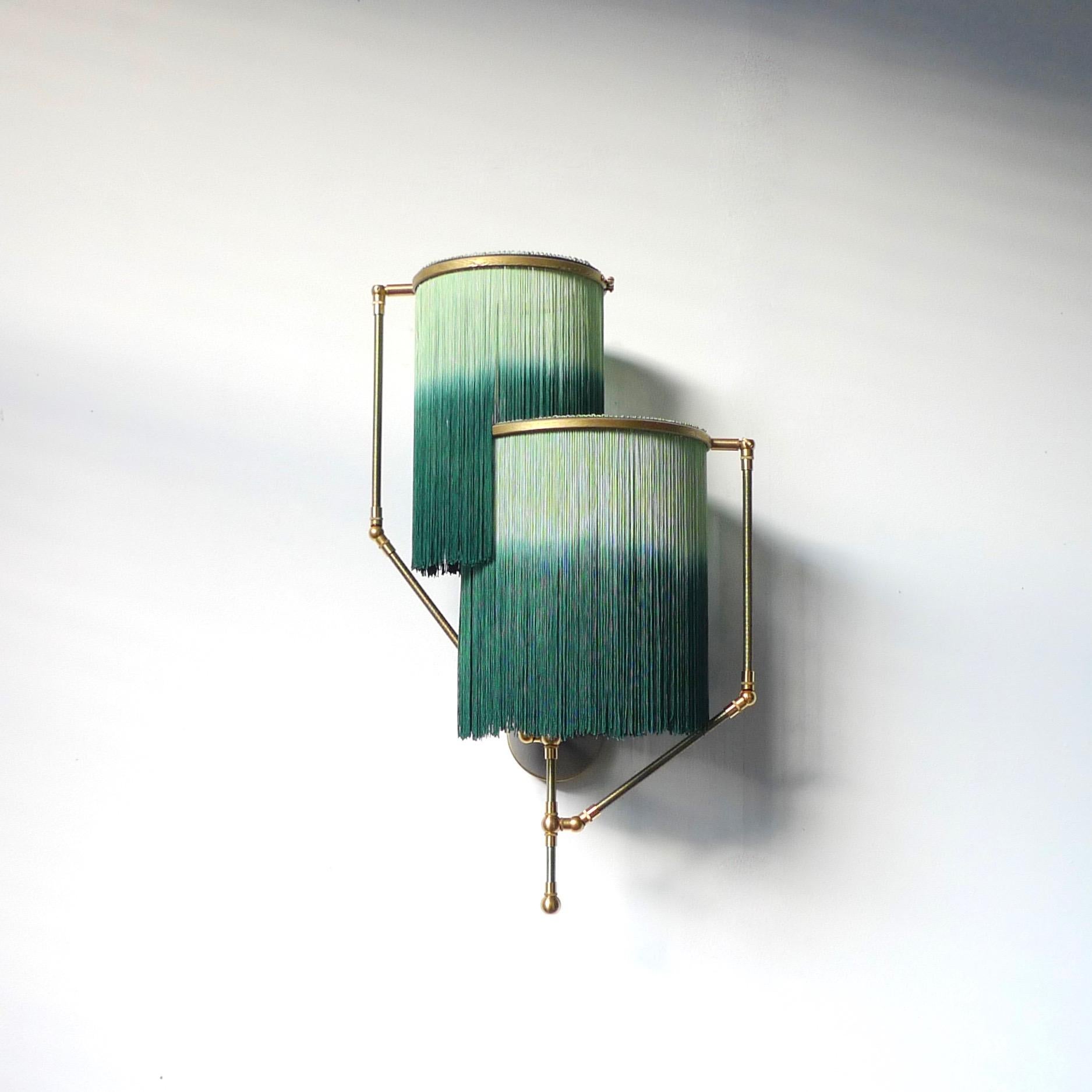 Green charme sconce lamp, Sander Bottinga

Dimensions: 50 x W 38 x D 27 cm
Hand-Sculpted in brass, leather, wood and dip dyed colored Fringes in viscose.
The movable arms makes it possible to move the circles with fringes in differed