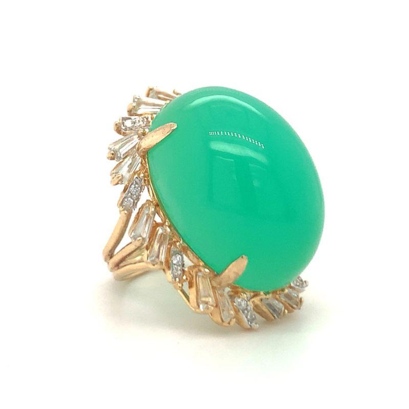 One green chrysoprase-chalcedony 14K yellow gold diamond ring centering one vibrant green oval cabochon chrysoprase. Surrounded by 16 round brilliant cut diamonds totaling 0.25 ct. with I-J color and VS-2 clarity along with 16 tapered baguette