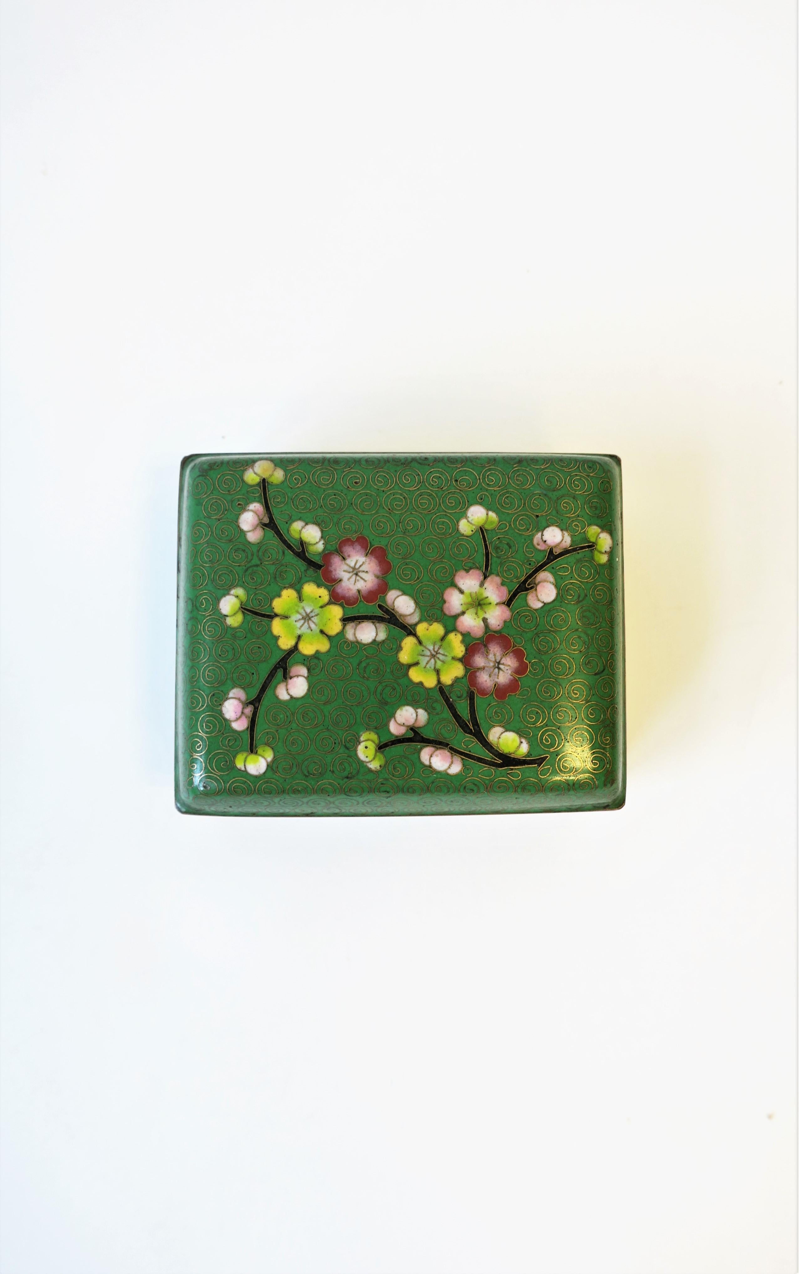 An enamel cloisonné and brass jewelry box with cherry blossom design, circa late-20th century. Box is great for jewelry or small items on a vanity, desk, nightstand table, etc. Colors include green, light green, gold, brass yellow, pink, red