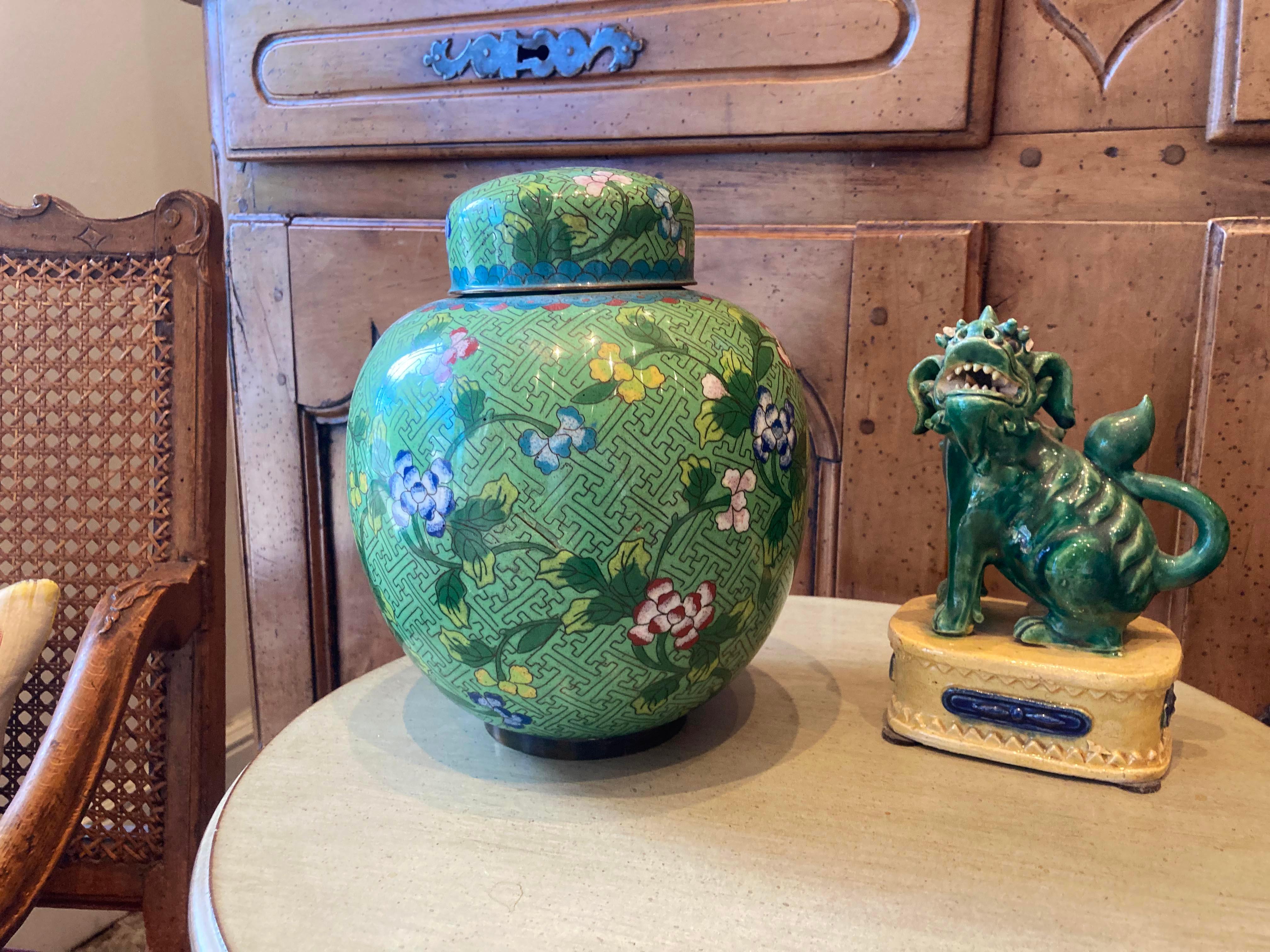 Green cloisonné jar is in excellent condition with beautiful lustre to the smooth finish of the enamel. The removable lid interior is a sky blue enamel as well as the interior of the jar. Features beautiful intricate diapered background pattern.