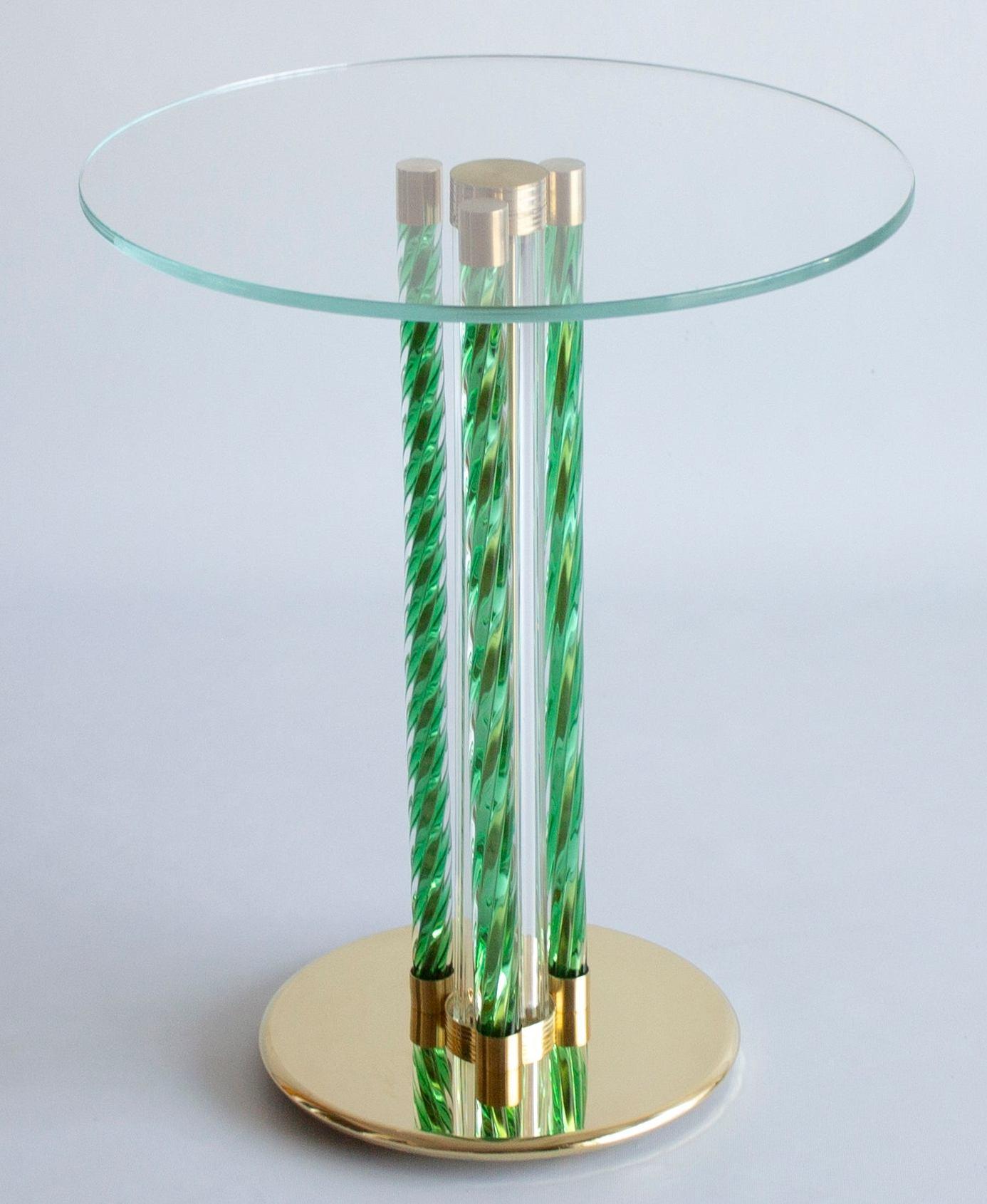 Elegant green cocktail table in blown Murano glass and brass frame Italy Contemporary.
This coffee table is a work of art composed by three main twisted pillars in green color entirely handcrafted in blown Murano glass. In the very center another