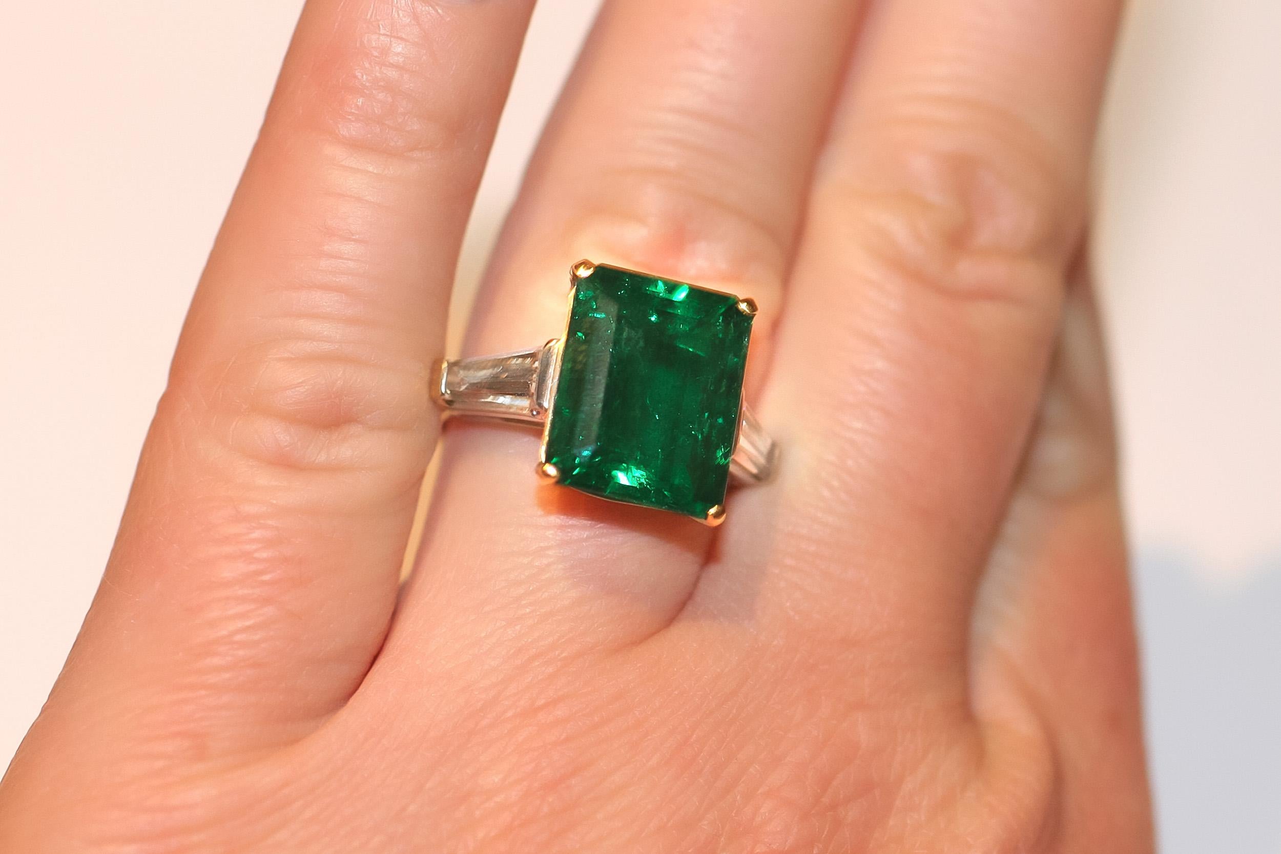 Colombian Green Emerald weighing 6.72 carat set in handmade ring crafted in Platinum and 18k & 18K Yellow Gold with 2 Trapezoid cut Diamonds weighing a total of 0.56 carats. 
AGL # CS55546

Viewings available in our NYC wholesale office by