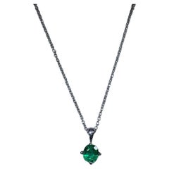 Green Colombian emerald round shaped solitaire pendant in 18k white gold.