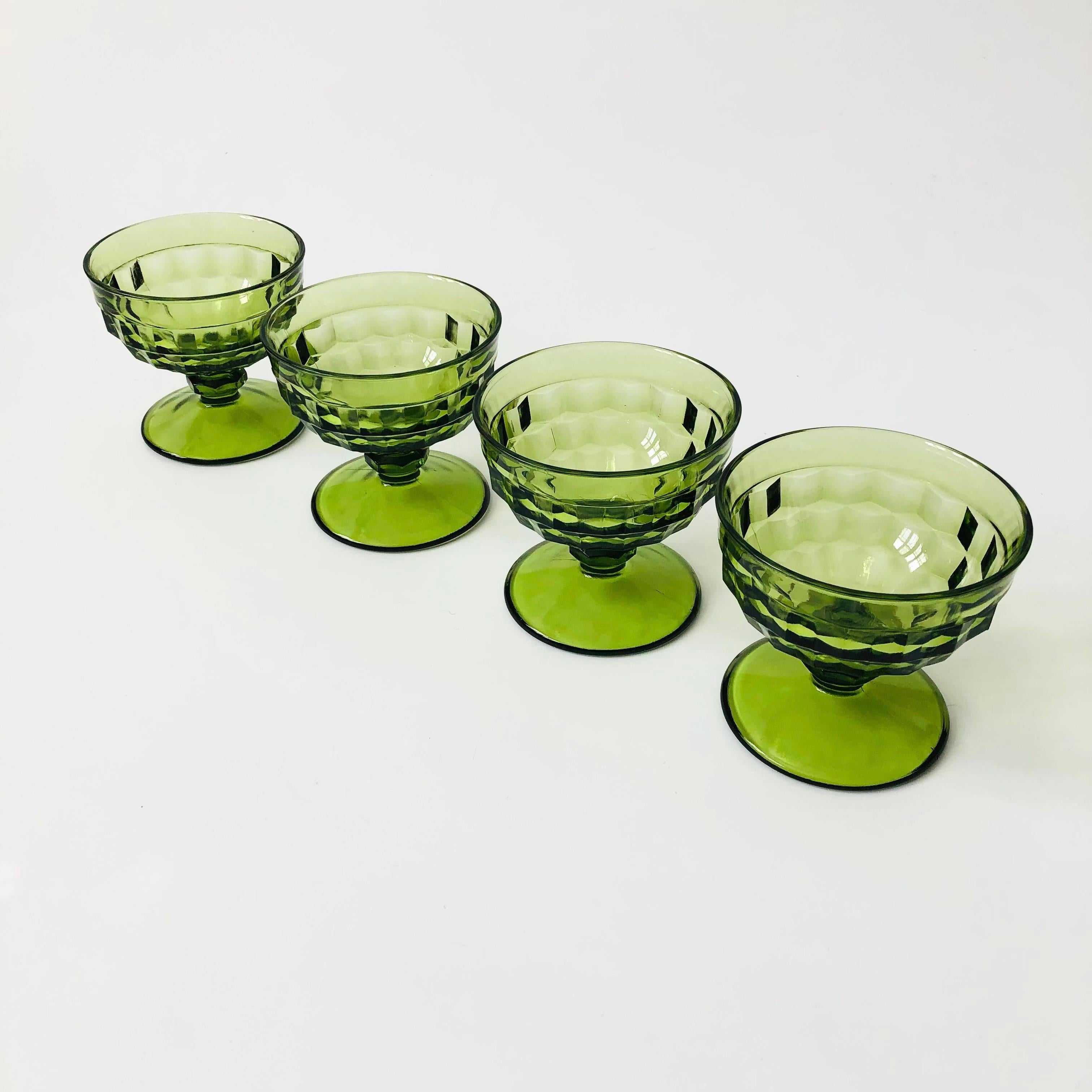 A set of 4 vintage coupe glasses with a cubist design in green glass. Made in the Whitehall pattern by Indiana Glass. Perfect for wine or champagne. Smooth interiors.

