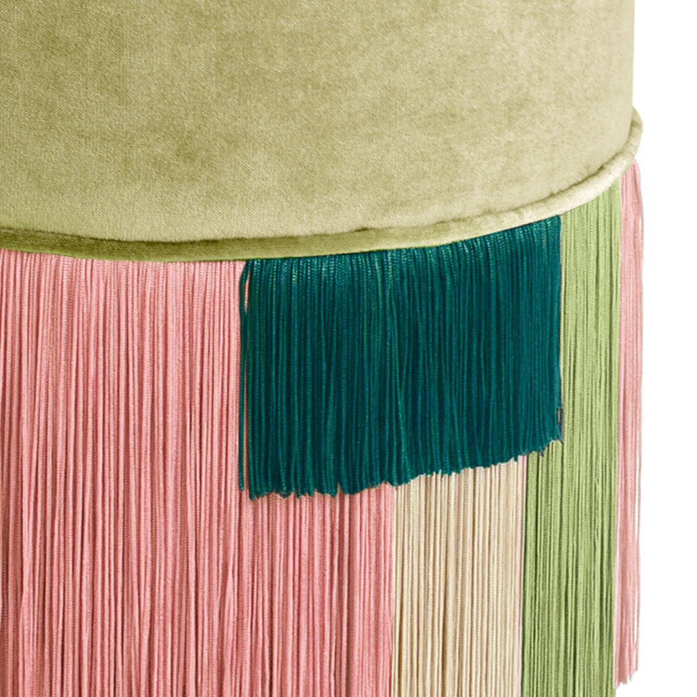 Si tratta di un pouf cilindrico unico nel suo genere grazie ai molteplici strati di frange in viscosa. Sono di diversi colori e lunghezze e creano un motivo artistico e geometrico unico. La base è in legno di faggio verniciato e il piano è imbottito
