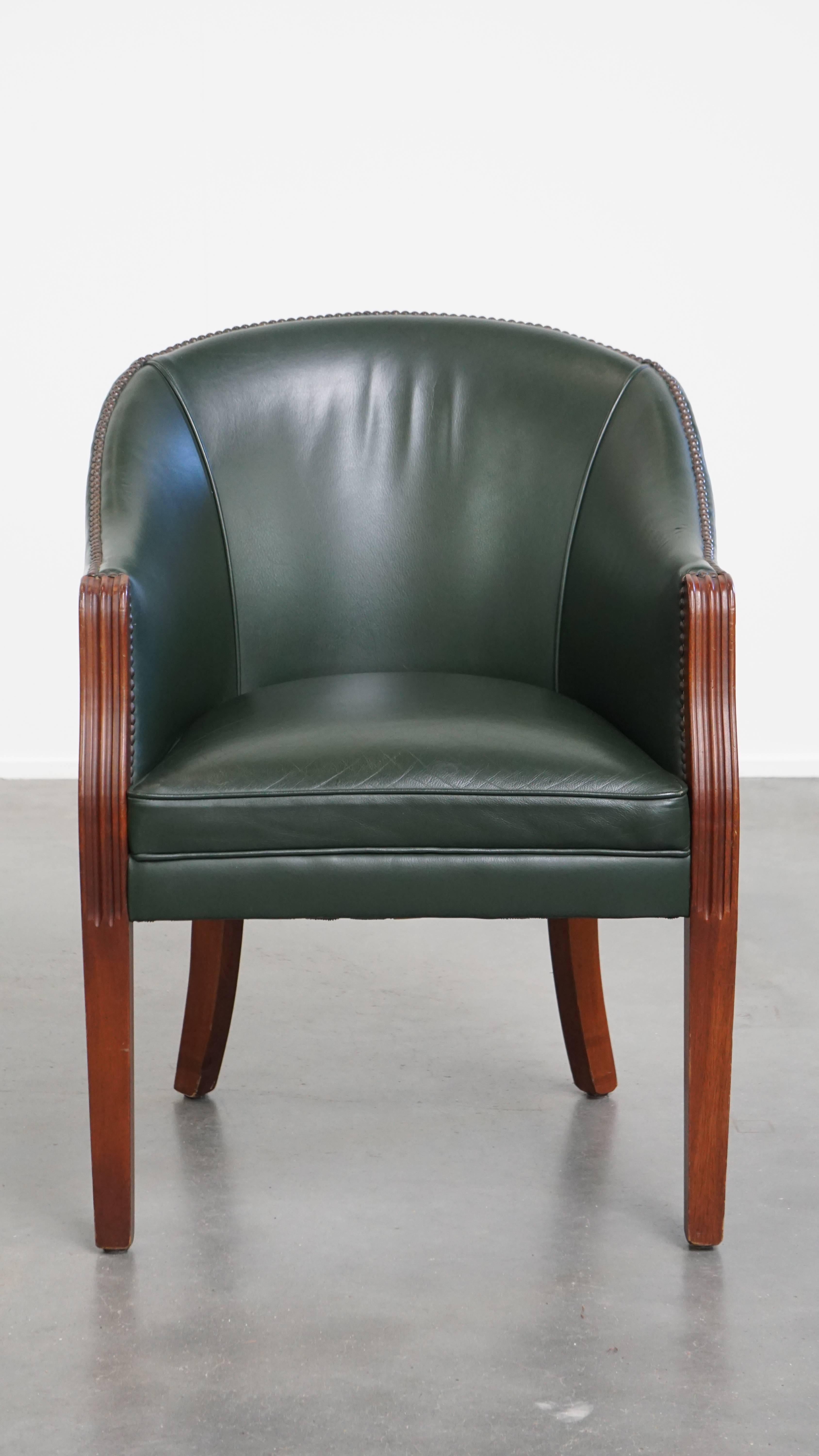 Offered: this charming green cowhide leather and wooden side / dining / desk chair in English style.

This wonderful leather chair features a fantastic green color and can be easily placed in both classic and modern interiors. It is not only a