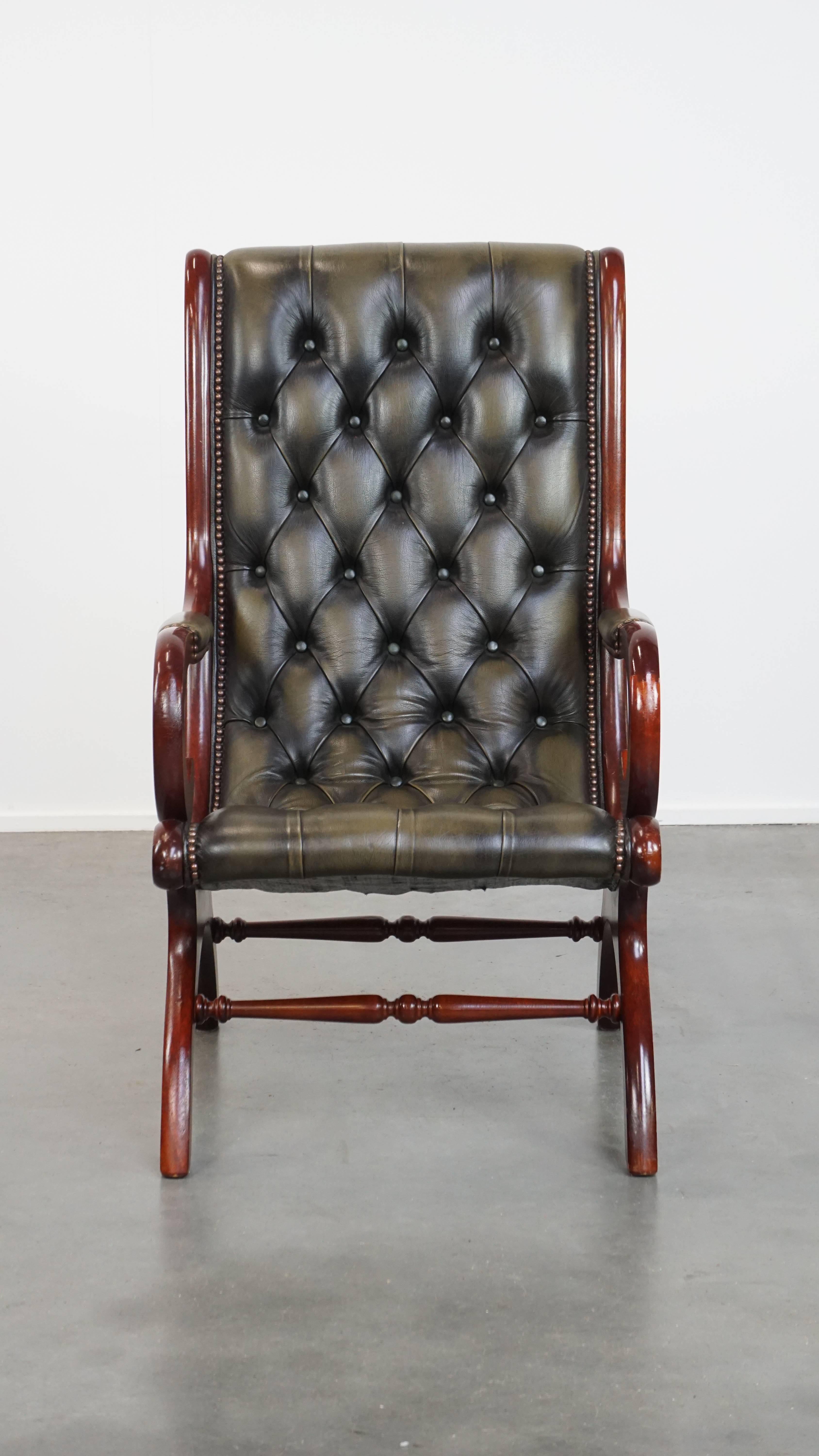 Angeboten wird dieser elegante englische Chesterfield-Sessel aus grünem Rindsleder mit anmutigen Holzdetails. 

Verleihen Sie Ihrer Einrichtung einen Hauch von zeitloser Eleganz mit diesem atemberaubenden Chesterfield-Sessel. Das aus Rindsleder