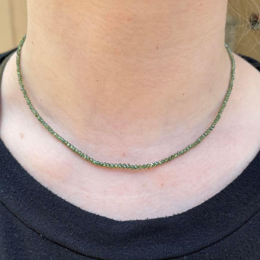 A 16 inch, 17 total carat weight dark green diamond necklace with a 14k yellow gold clasp. This necklace was made and designed by llyn strong.