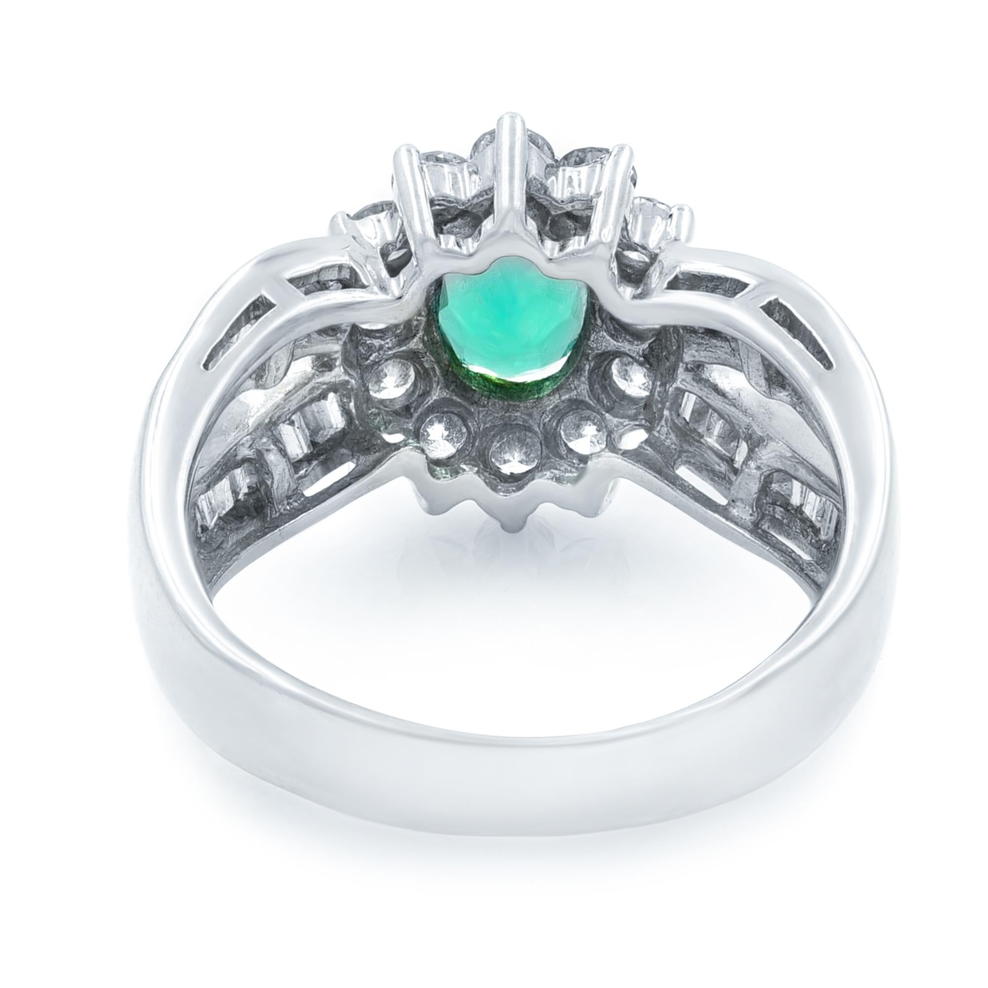 A modestly proportioned gorgeous, vibrant green 1.00 carat emerald, fashioned in a striking oval-cut shape, centers a classic retro sparkler, hand fabricated in 18k white gold geometric design and embellished all around with small round diamonds and