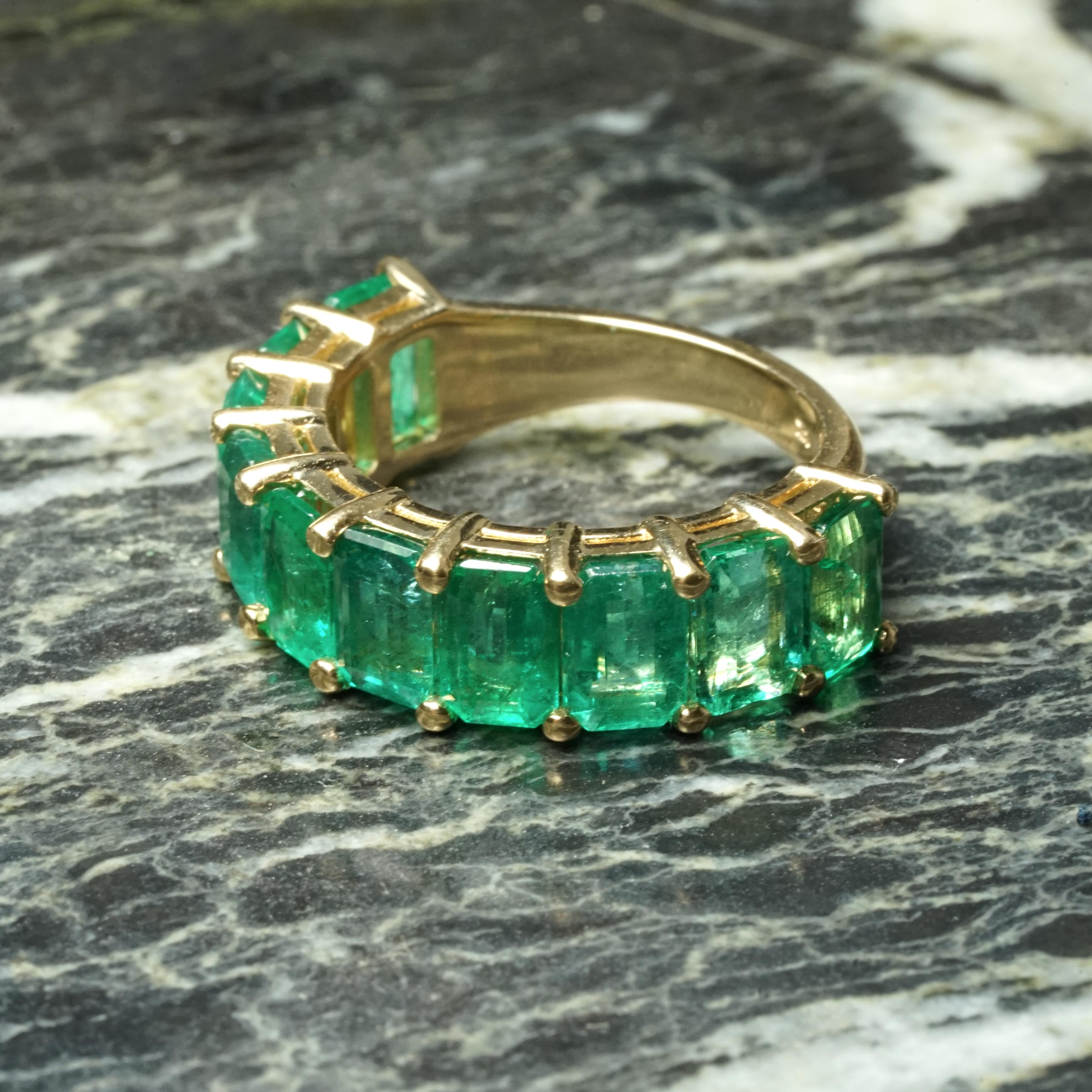 This stunning band showcases 5.96 carats of natural bright green emeralds in a classic ⅔ eternity design, offering the elegance of an eternity band with the added benefit of resizing flexibility. The ⅔ design provides the look of a full eternity