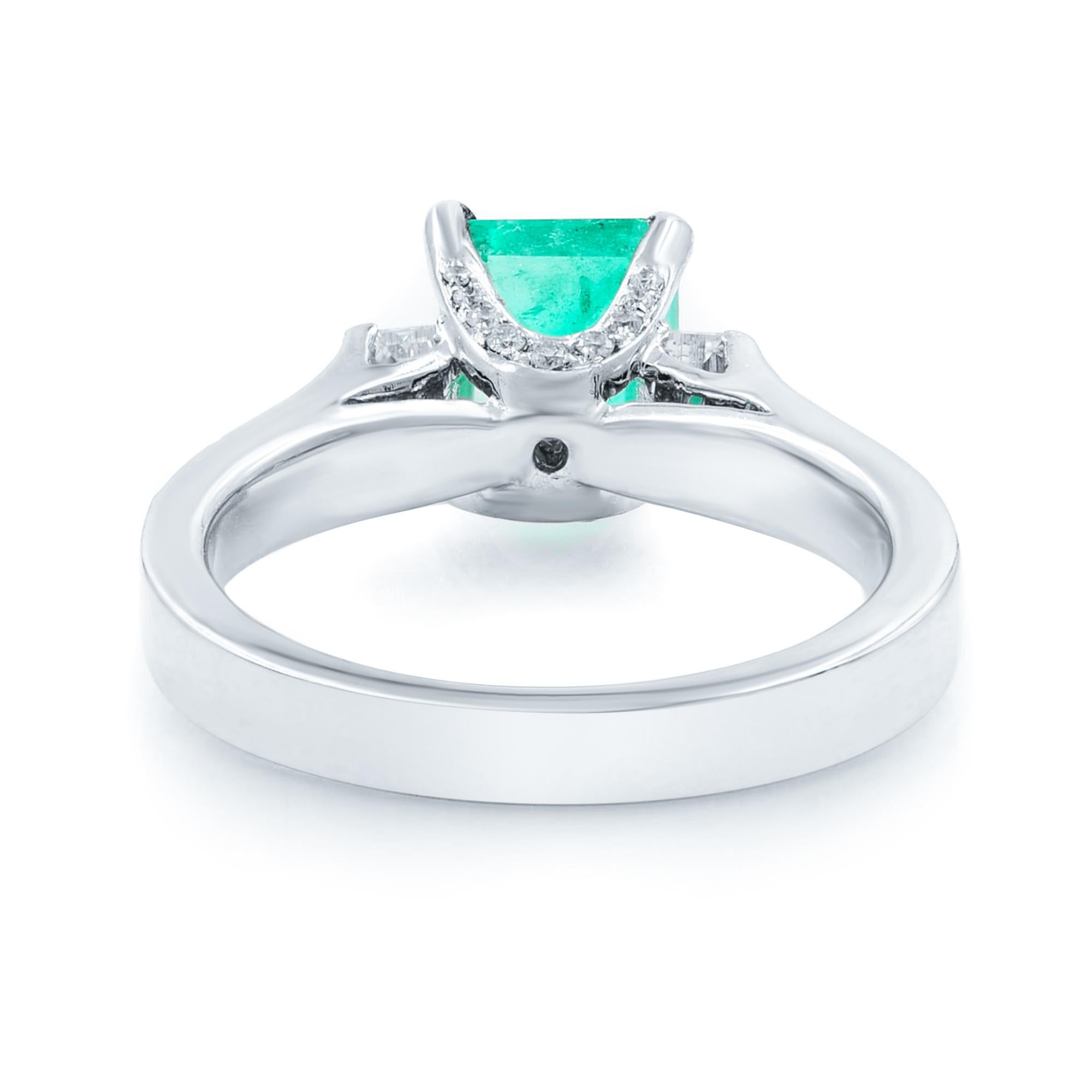 A gorgeous, richly saturated, crystalline green, sleekly modeled, emerald-cut Colombian emerald, weighing 1.71 carats. Glistens and glows between double rows of round brilliant-cut diamonds in this classic and pristine estate jewel crafted in
