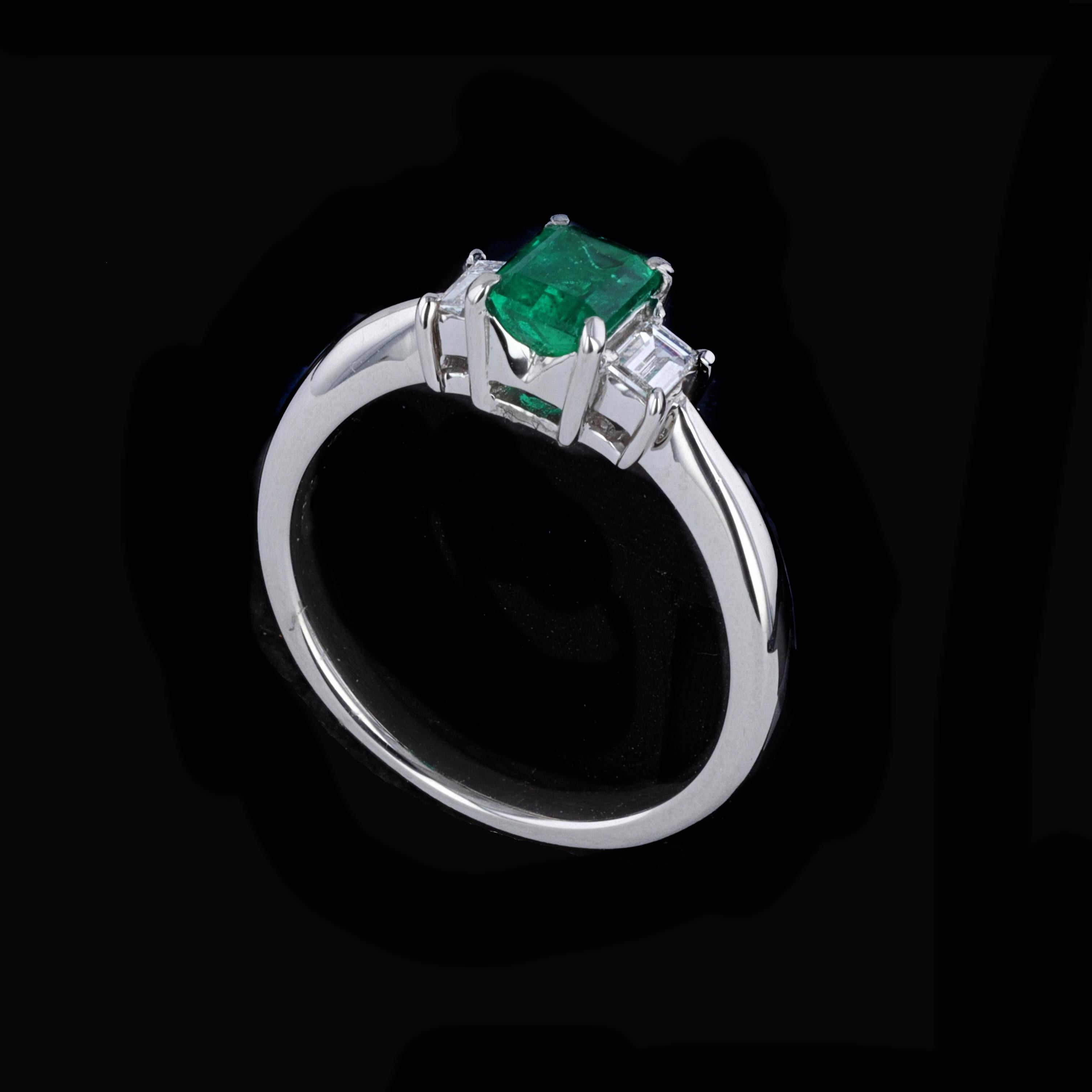 Exceptional and elegant 0.58ct Emerald 0.18ct Diamond Platinum Ring. The ring is centered with emerald cut emerald that weighs approximately 0.58ct. The emerald is accentuated by 2 emerald cut diamonds that weigh approximately 0.18ct. The color of