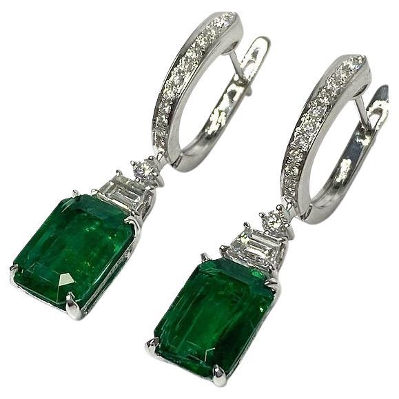 This stunning set of earrings features a mixture of resplendent green emeralds and sparkling white diamonds. Each piece features a stunning emerald cut green emerald. Each emerald is set in a classic 4 prong setting to minimize metal and maximize