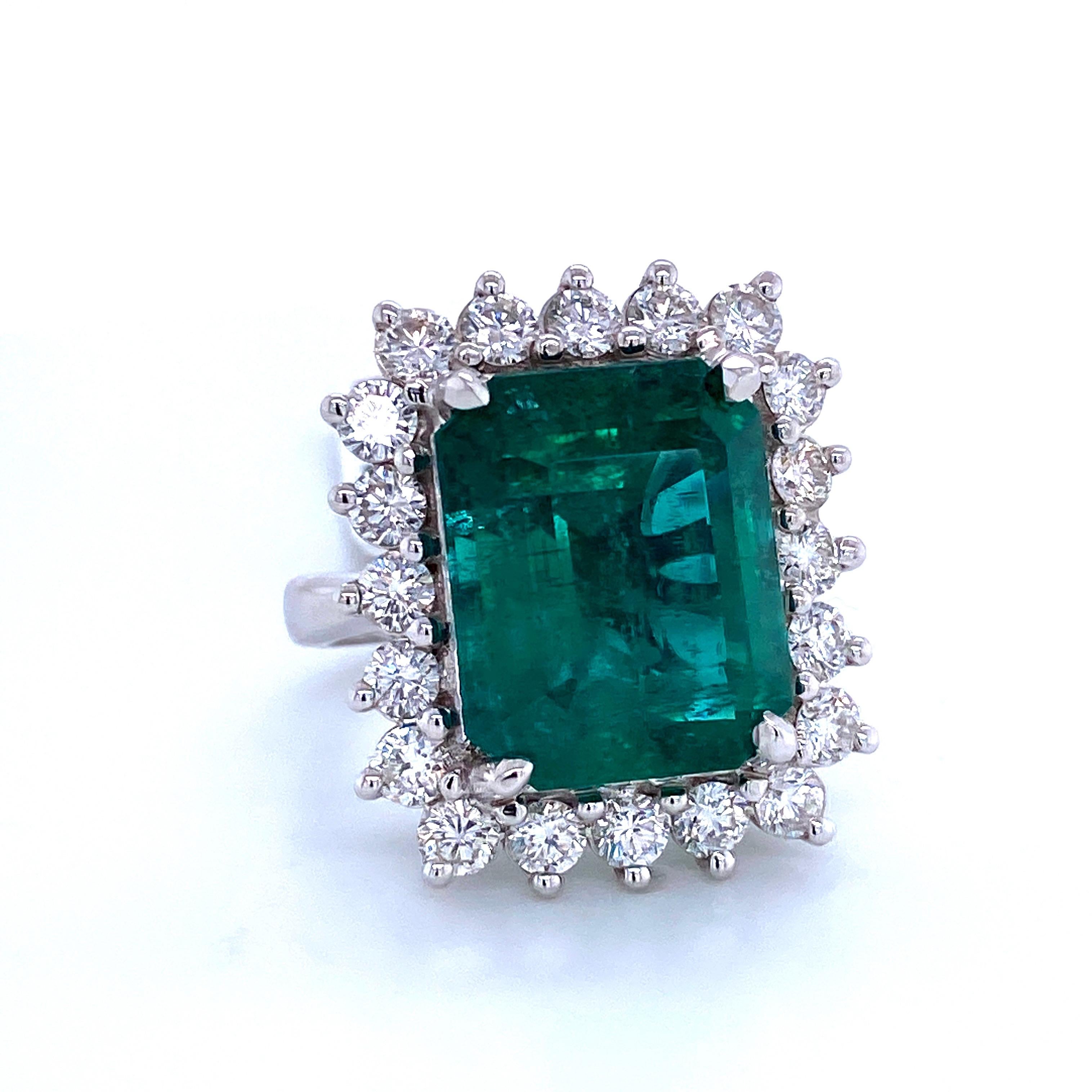 18K White gold cocktail ring featuring one green emerald cut Emerald weighing 12.35 carats flanked with 20 round brilliants weighing 2.10 carats,
