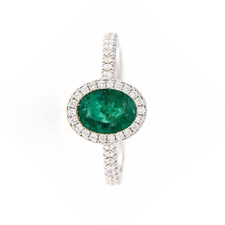 Questo squisito anello da abito in oro bianco 18 carati mostra una raffinatezza senza tempo, con al centro uno smeraldo verde vivo che irradia eleganza e fascino. 

Lo smeraldo è splendidamente completato da un'aureola e da spalle di scintillanti