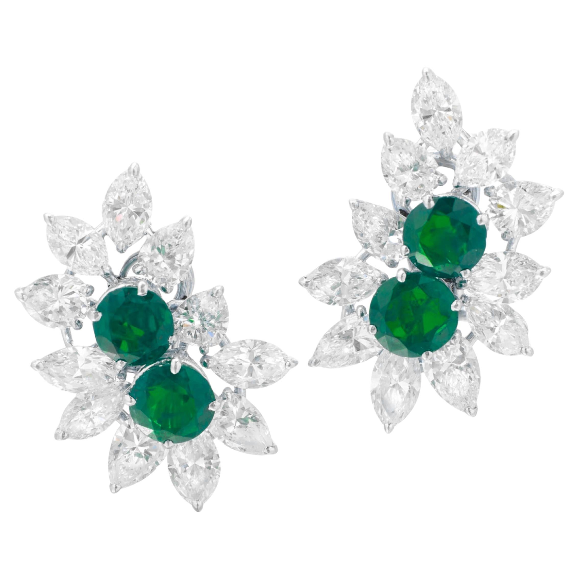 An exquisite pair of floral design emerald and diamond earrings

Each decorated with a floral design enhanced with circular-cut emeralds surrounded by marquise and pear-shaped diamonds.

