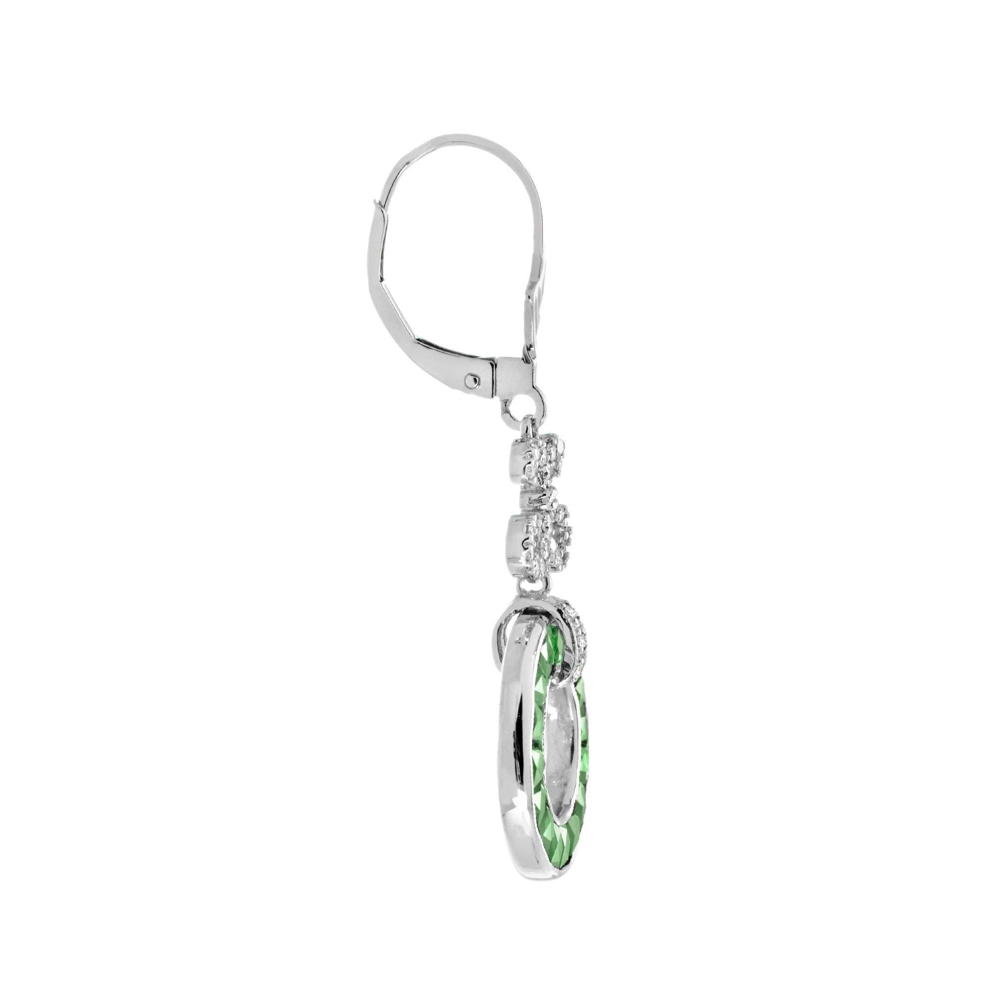 A pair of Art Deco style emerald and diamond drop earrings, set with round French cut emerald open circle suspended from a row of round diamond. A really useful everyday ear stud that you will fall in love with. 14K White Gold. 
Earrings