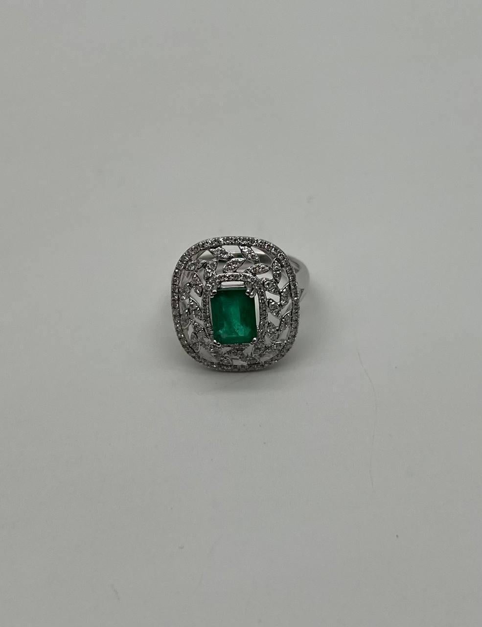 A stunning emerald ring. This exquisite piece features a captivating emerald set in a beautifully intricate design. The central emerald is a vibrant green, surrounded by a halo of sparkling diamonds that enhance its brilliance. The setting is