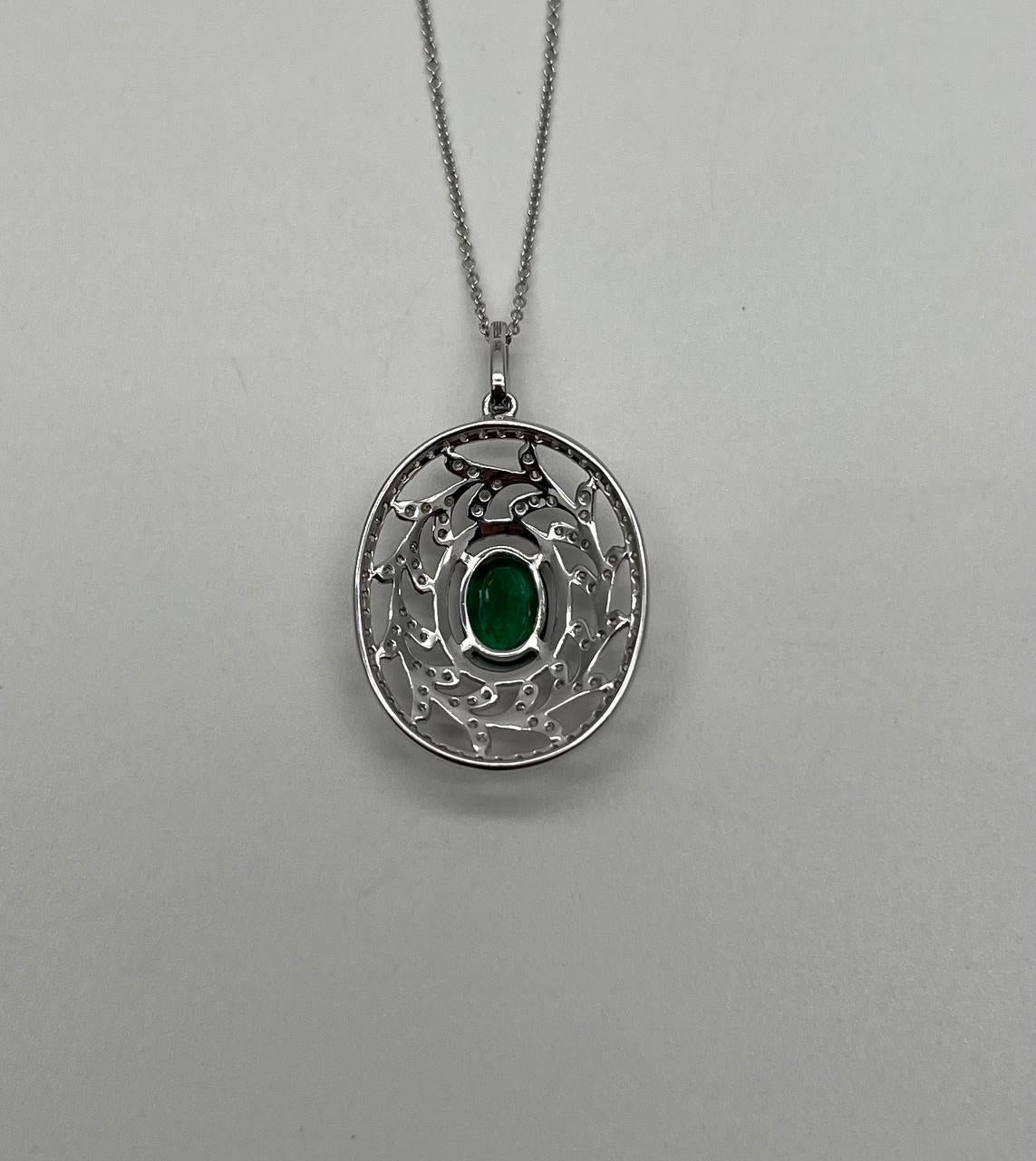 This exquisite necklace is crafted in 14k white gold. The pendant features a striking green emerald at its center, weighing approximately 1.14 carats. Surrounding the emerald are dazzling white diamonds, totaling approximately 0.57 carats, with a