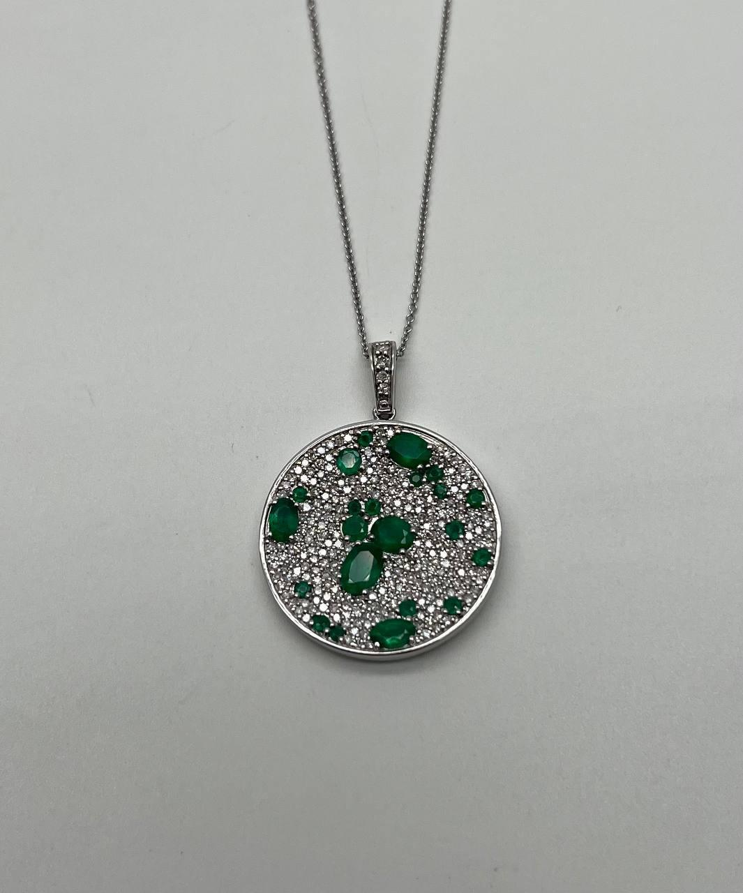 Questa straordinaria collana con ciondolo è sapientemente realizzata in oro bianco 14k. Il pendente presenta smeraldi verdi e vibranti, per un totale di circa 2,3 carati, incastonati su uno sfondo di diamanti bianchi abbaglianti, per un peso totale