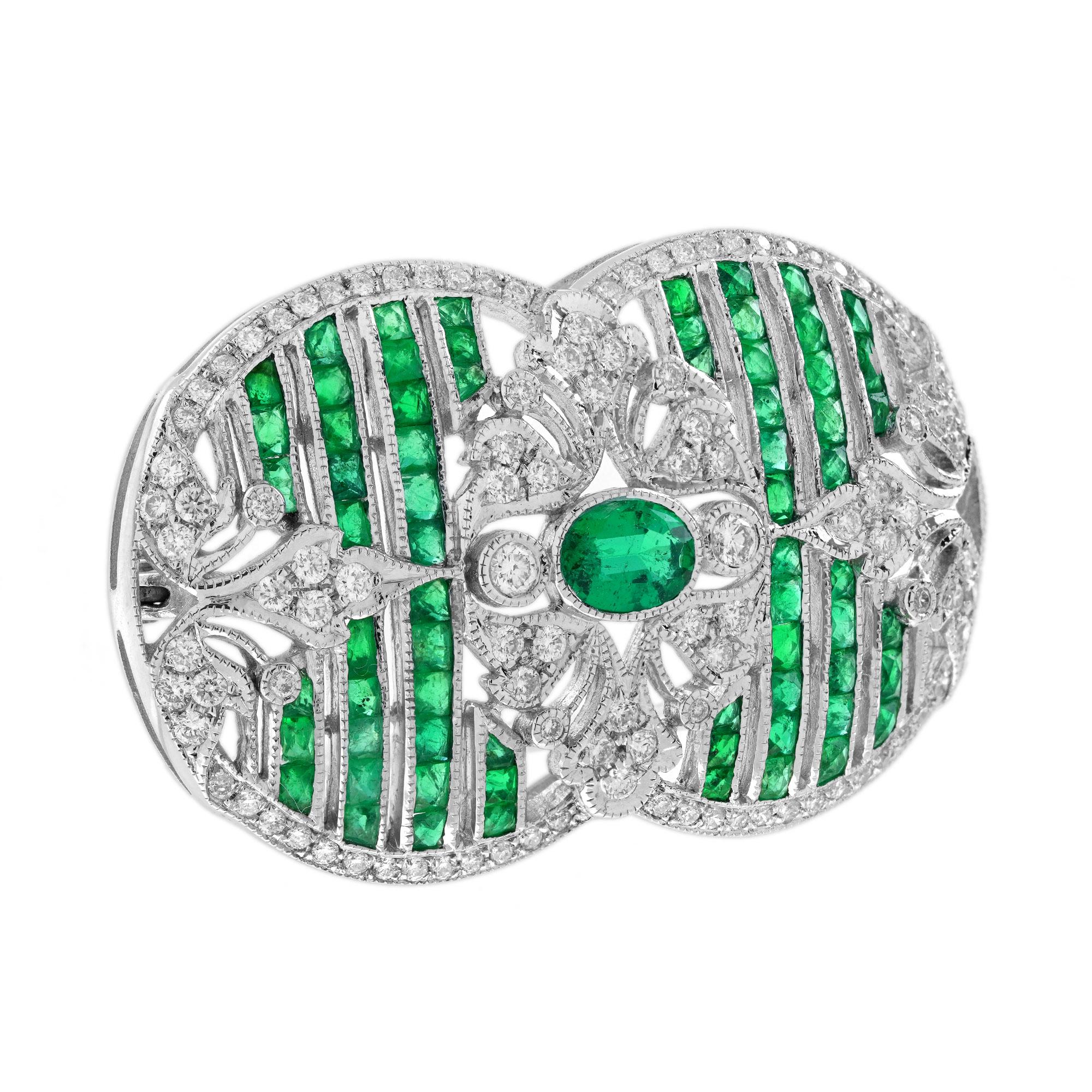 Light up your lapel with this strikingly stunning brooch of exceptional quality. Its focal piece is a gemmy green 0.40 carat oval emerald, highlighted on each side by glittering diamonds and small French cut emeralds. A tres chic and magnifique Jazz