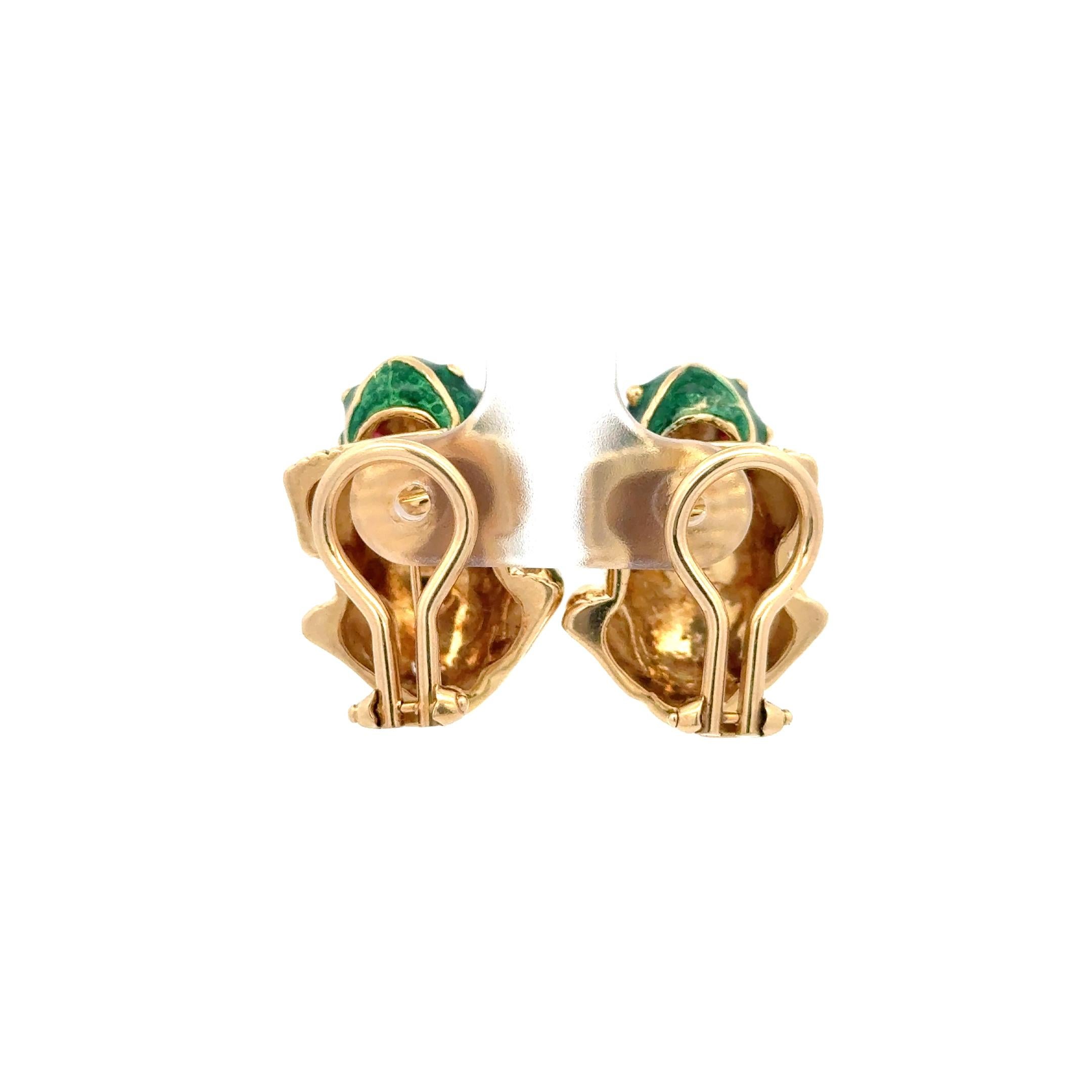 Green Enamel Frog Earrings in 14K Yellow Gold. The frogs feature cabochon cut ruby eyes. Clip-on backs. The frogs measure approximately 1 inch by 0.70 inches, and have a total weight of 23 grams.