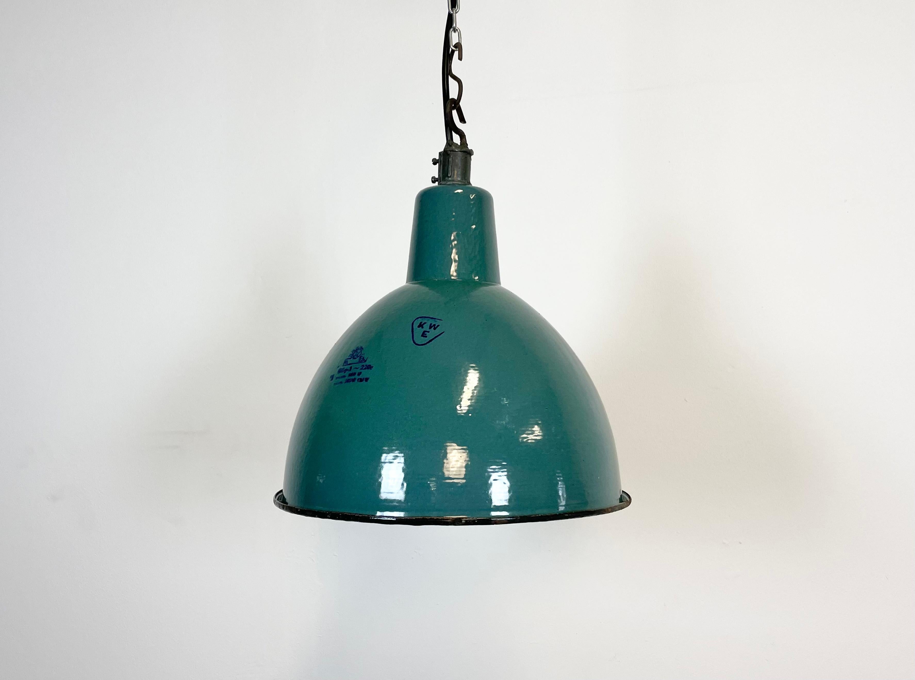 Industrial green enamel pendant light made by KWE in Poland during the 1960s. White enamel inside the shade. Iron top. The porcelain socket requires E 27 light bulbs. New wire. Fully functional. The weight of the lamp is 2 kg.