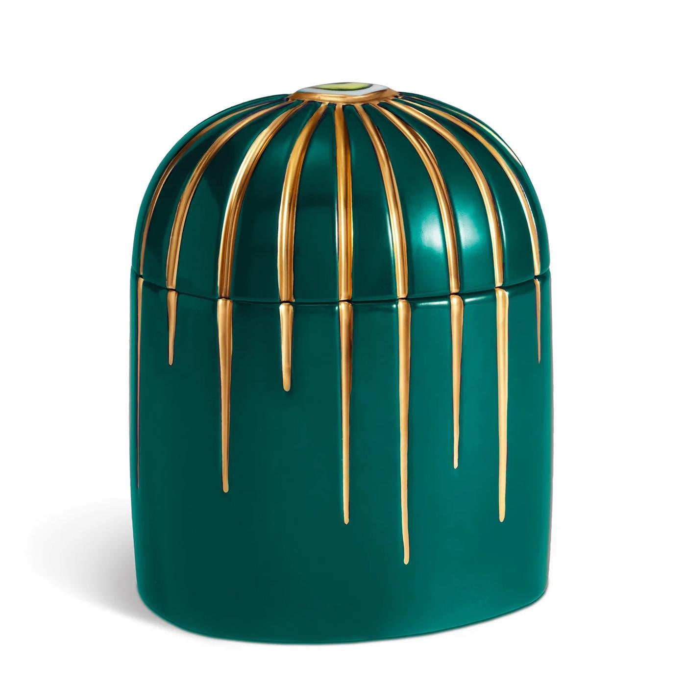 Caja para velas Ojo Verde de porcelana con
un ojo verde porcelana en el párpado. En azul oscuro 
porcelana con acabado chapado en oro de 24 quilates. 
Incluye cera de parafina con mecha simple, fragancia 
vetiver verde. Se entrega en una lujosa caja