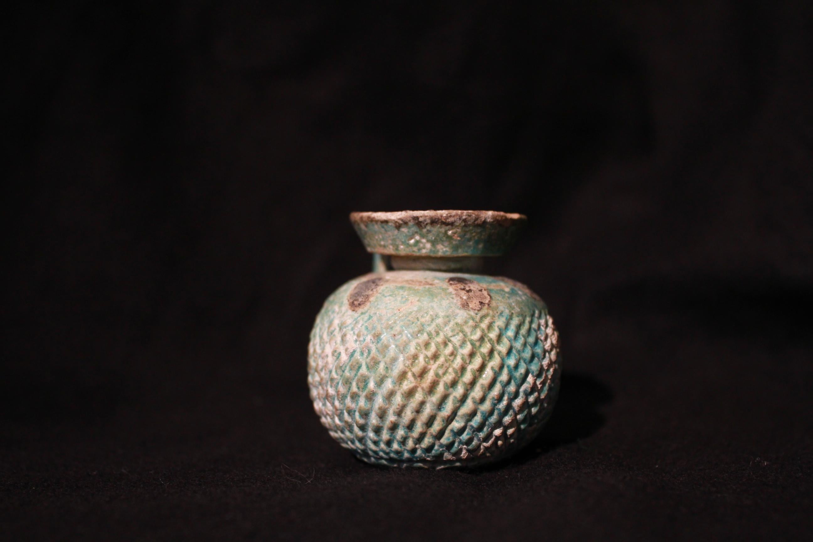 This small green faience aryballos most likely used to contain either perfume or essential oil used in private baths, banquets or funerary rituals during the antique world. Such containers are well attested for in Ancient Greece and Egypt.
