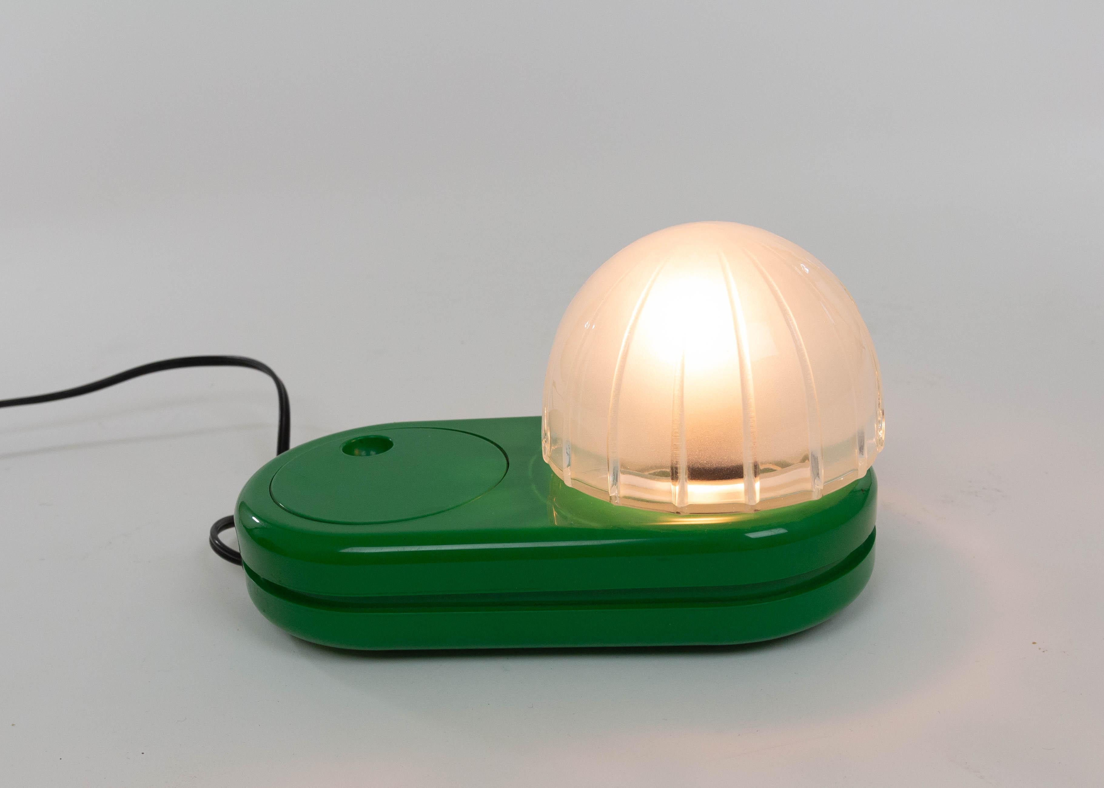 Grüne Tischleuchte Farstar, entworfen von Adalberto Dal Lago (1973) und hergestellt von Francesconi.

Der kuppelförmige Glasschirm sitzt auf einem Kunststoffsockel. Der große, runde Lichtdimmer, der auch als Ein- und Ausschalter fungiert, ist ein
