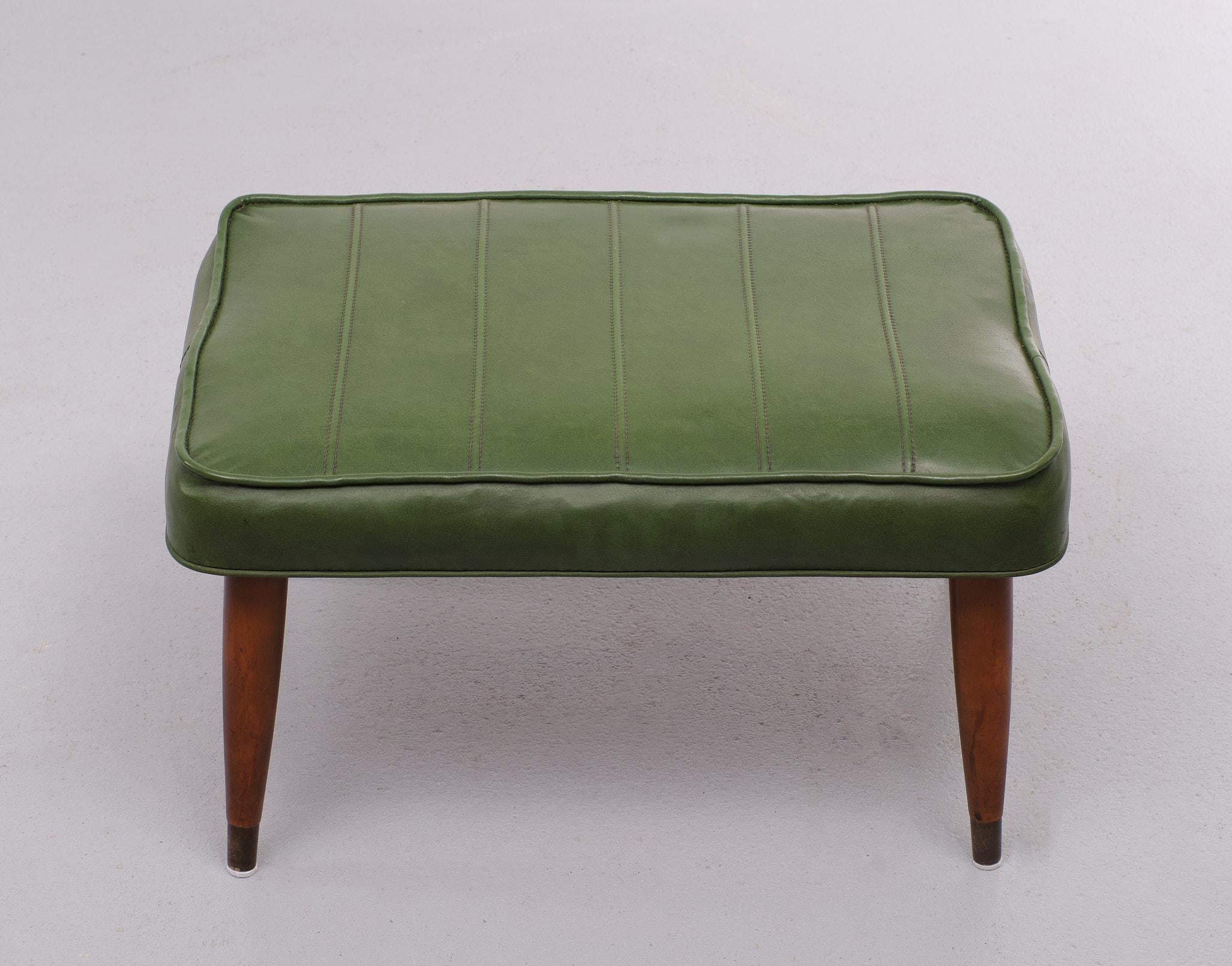 Very nice authentic foot stool. Green Faux Leather upholstery. Mahogany legs 
comes with Brass feet. Great looking stoo. Normal wear and tear.