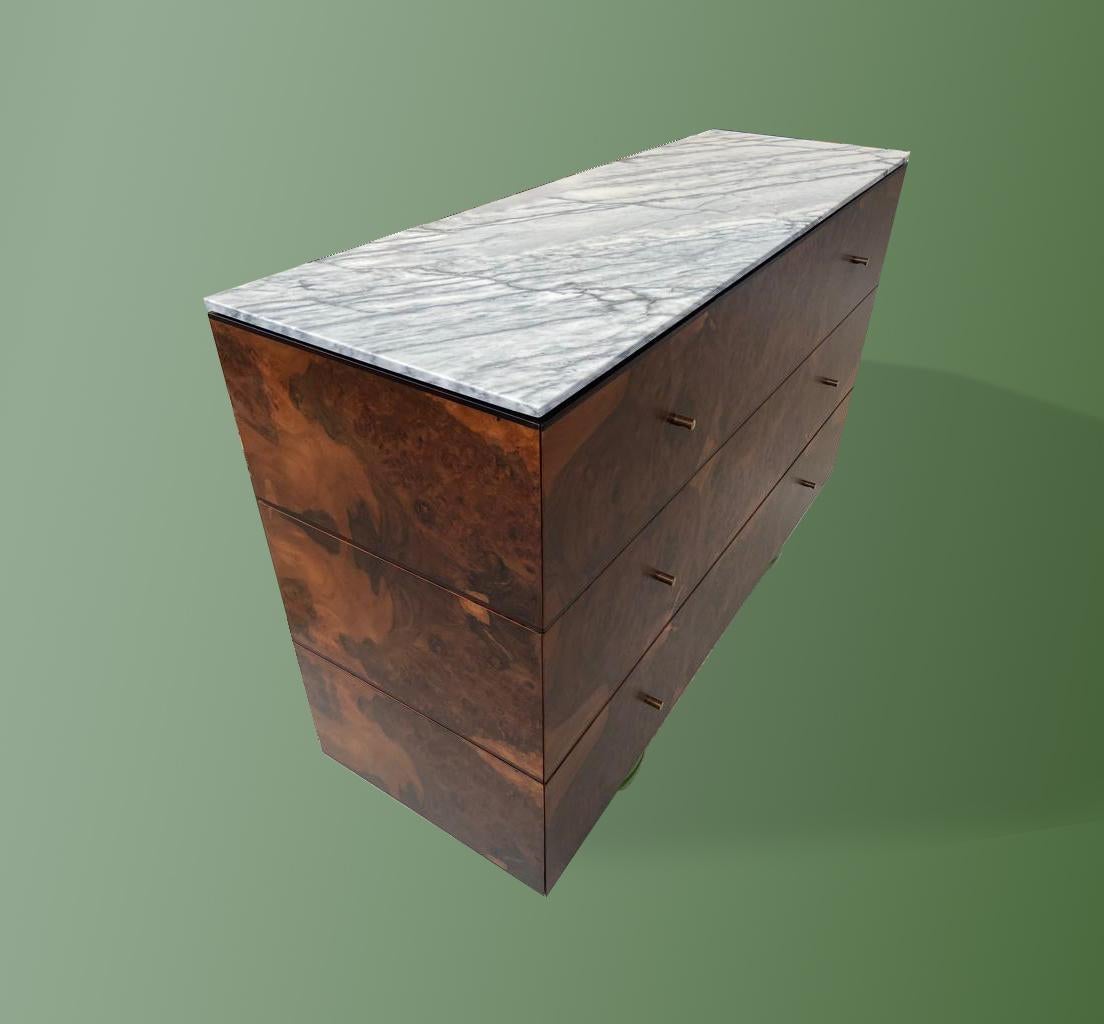 The Green Feet chest of drawers is made in burr walnut veneer with three lines that divide in equal spaces the three drawers. The top is made in estremoz marble; the legs are spray-painted. The colour of the legs can be changed as per client's
