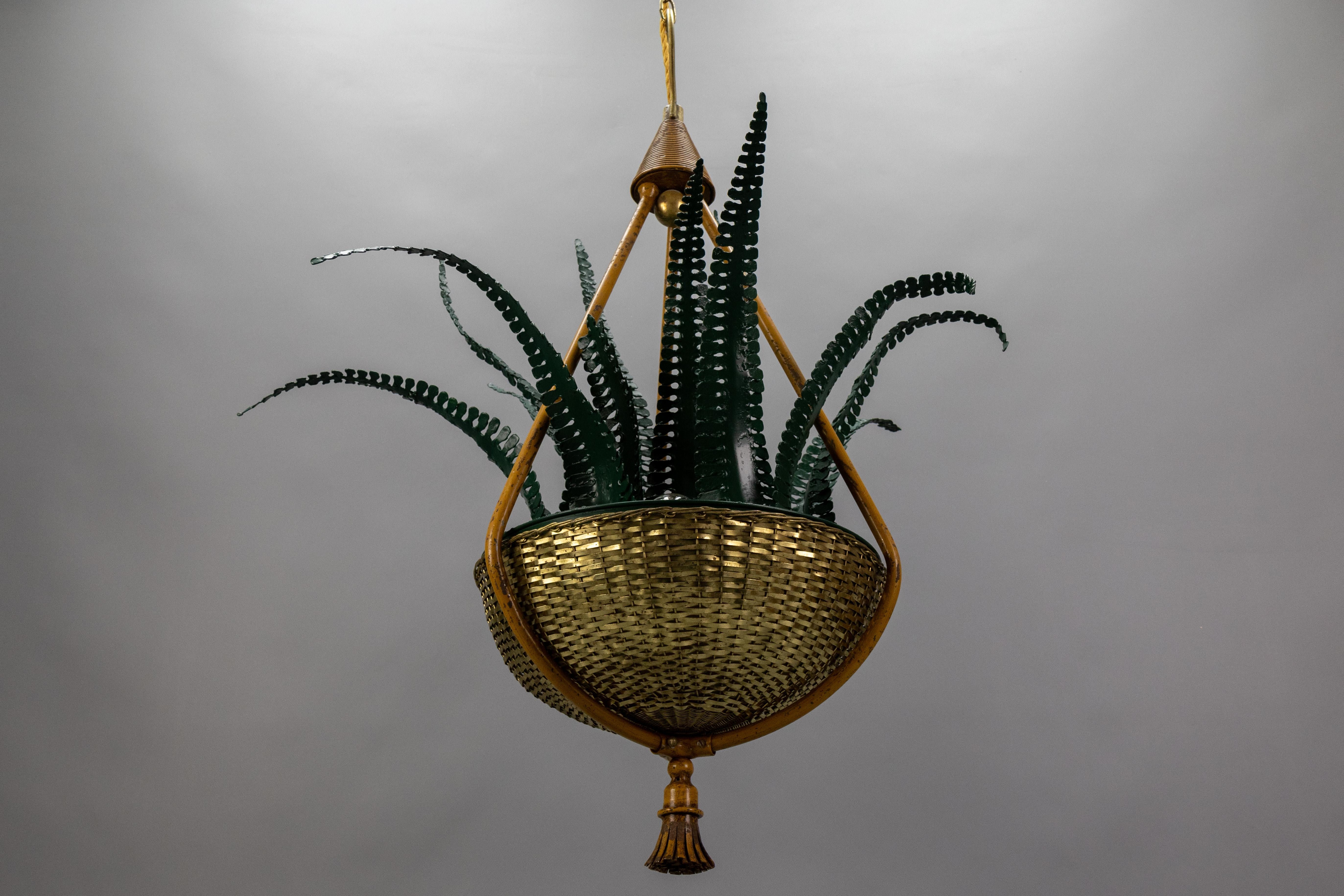 Lampadario a quattro luci con foglie di felce verdi e cesto in ottone, attribuito alla Maison Baguès, Francia, anni '50 circa.
Questo raro e straordinario lampadario botanico francese in stile Hollywood Regency è caratterizzato da foglie di felce