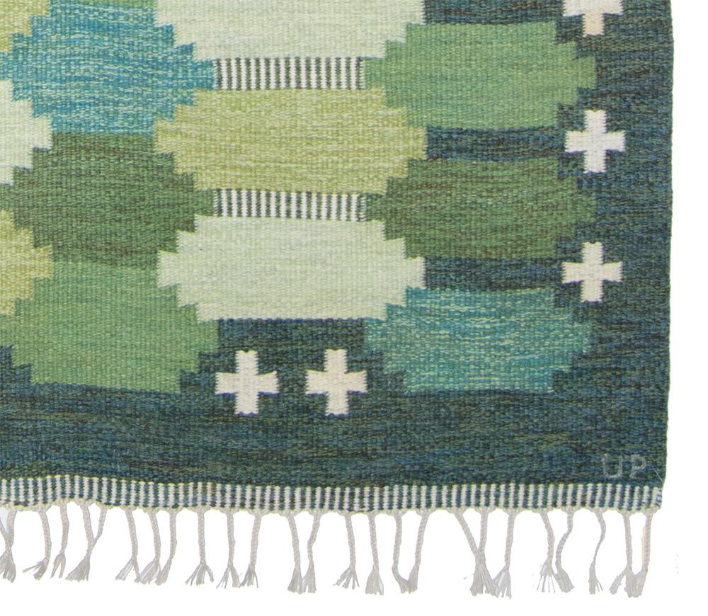 A green flat weaved rug by textile designer Ulla Parkdal, Sweden ca 1960s. Different shades of green combined with blue, light yellow and beige. This rug is handwoven in wool and signed UP, Ulla Parkdal, Sold in excellent conditions with no defects