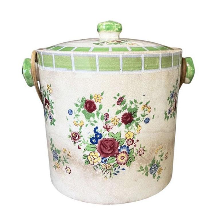 A petite ceramic ice bucket with a floral hand-painted design. This small vessel could be used in several ways. It could serve as an ice pail, wine cooler, biscuit holder or even as a vase for fresh flowers. (Side note: We've tested it, and it holds