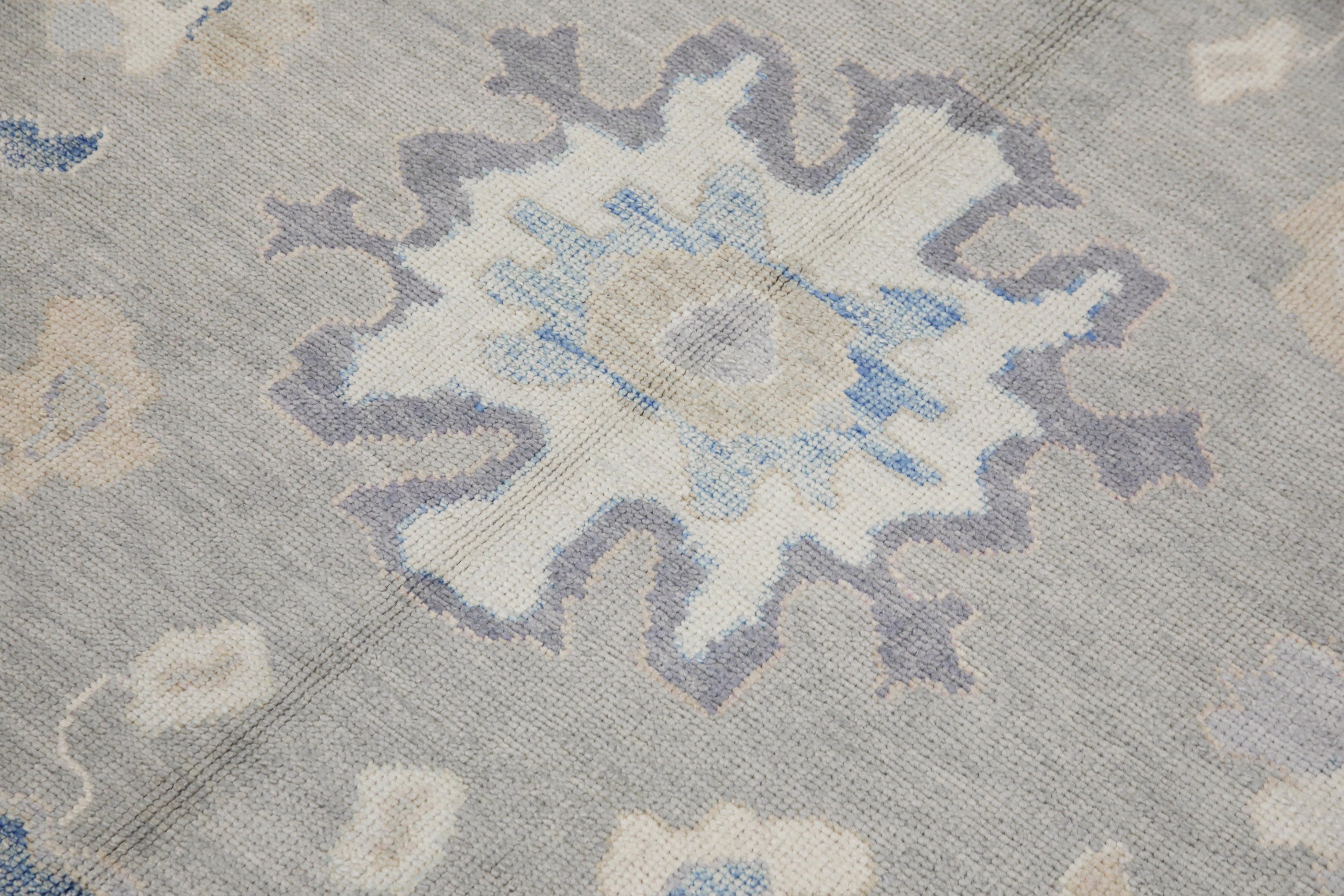 This modern Turkish Oushak rug is a stunning piece of art that has been handwoven using traditional techniques by skilled artisans. The rug features intricate patterns and a soft color palette that is achieved through the use of natural vegetable