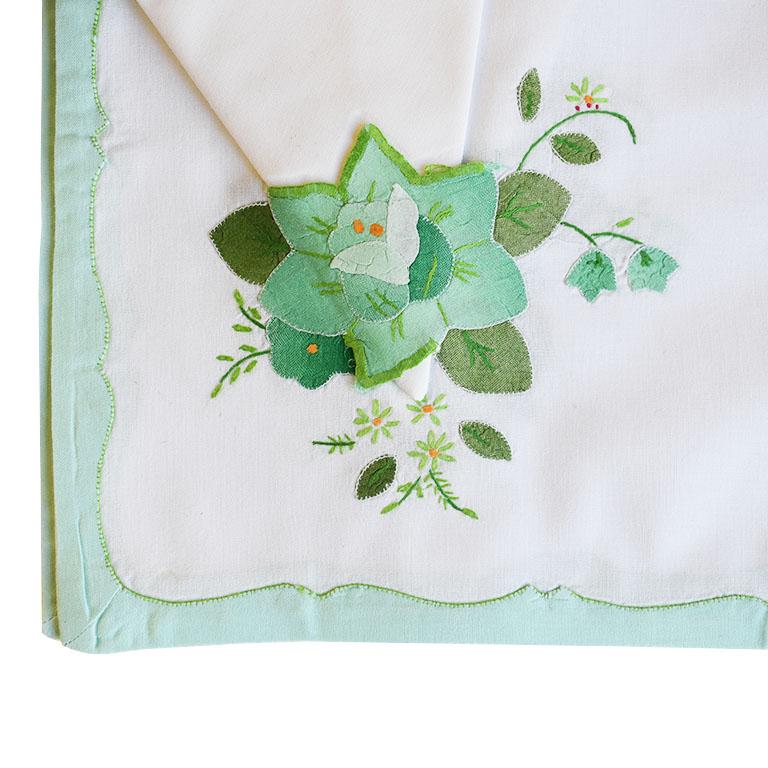 Set of four floral mint green cloth placemats and matching napkins. A wonderful accent to a table setting, each set includes one placemat with a matching napkin. A mint green scalloped edge lines the outside of each placemat. At the bottom left,