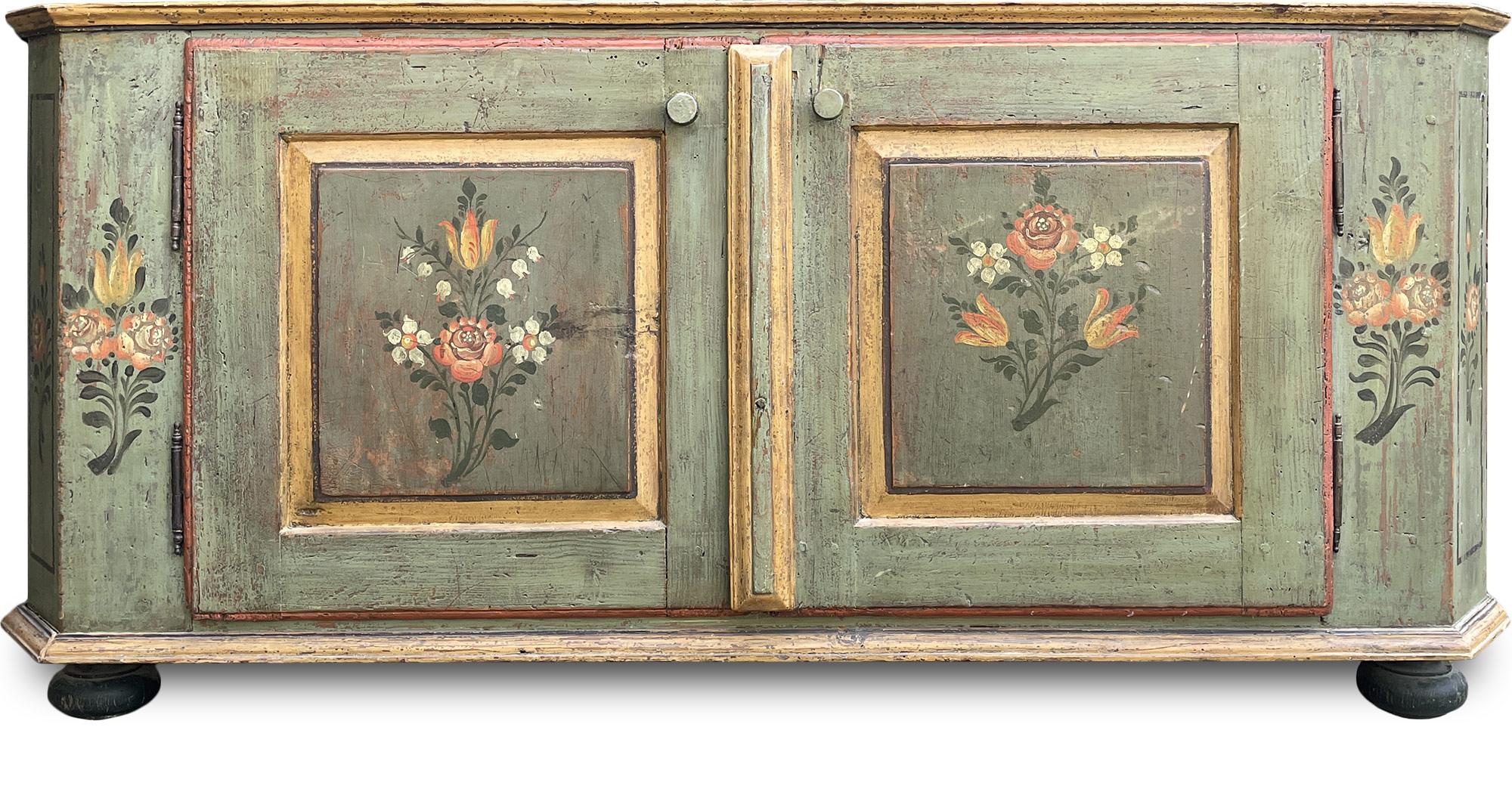 Tyrolean painted sideboard

Measures: H.70 - L.142 - P.38

Sideboard painted with two doors, entirely painted in sage green. Floral motifs are depicted on the doors, shoulders, notches and sides. Internally, the original shelves are still