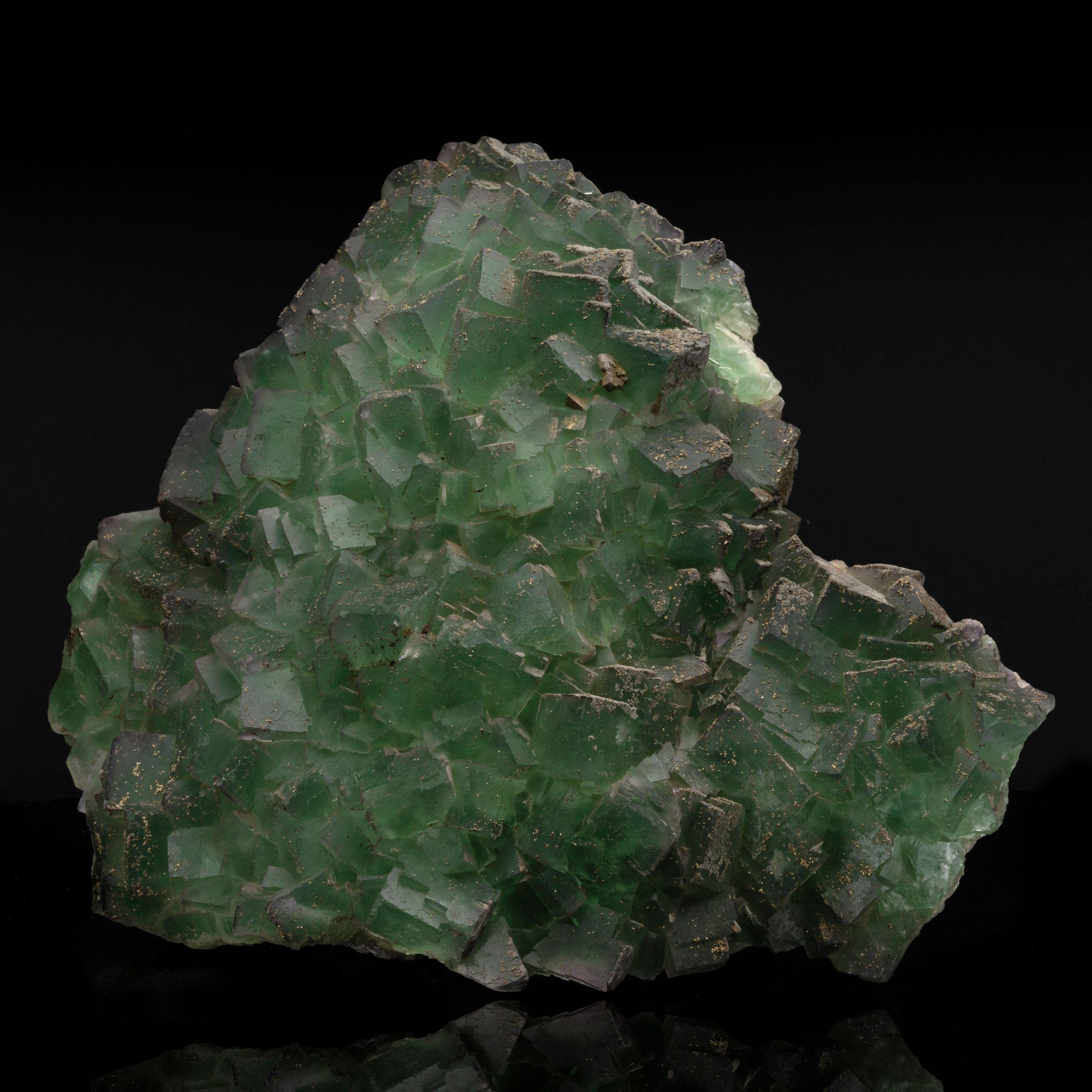 This large cabinet-size Moroccan fluorite specimen commands attention with its sharply-defined cubic crystals, offering excellent translucency and distinct green and purple color zoning. It glows beautifully under UV light, highlighting its