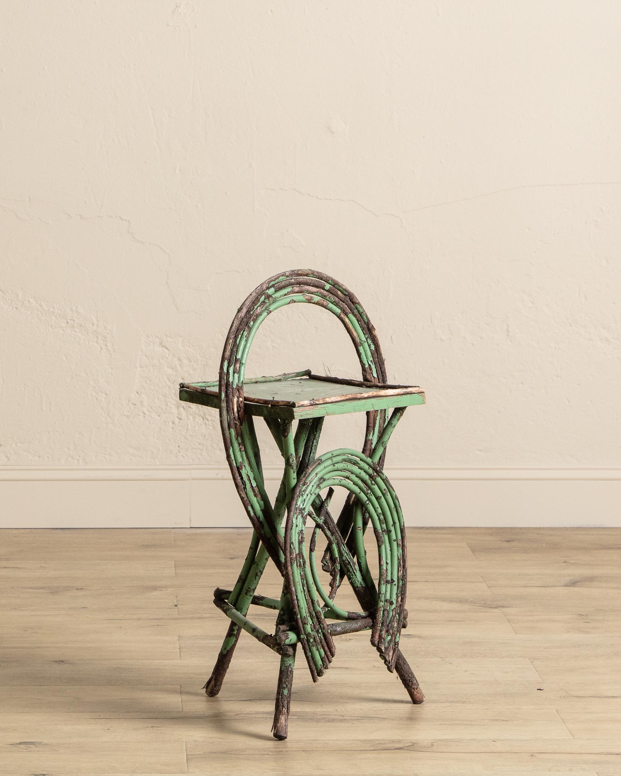Cette charmante table en brindilles du début du 20e siècle illustre l'art rustique des meubles de style Adirondack. Réalisé à partir de branches de bois courbé disposées en boucles circulaires, il allie une forme sculpturale à une texture naturelle.