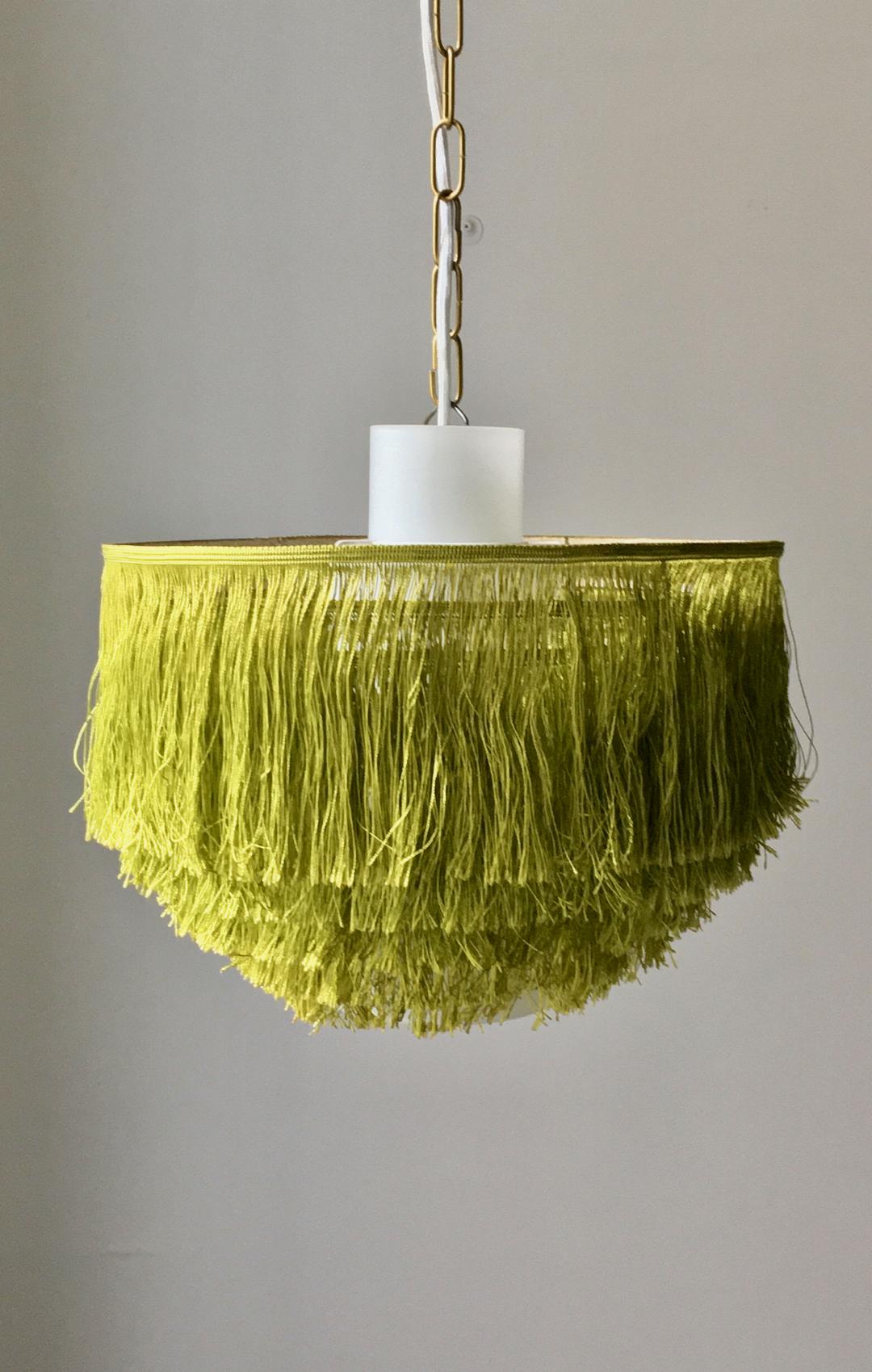 Green silk fringe light with glass liner by Hans-Agne Jakobsson, made by his company in Markaryd, Sweden. Two lights available, price is per piece.

The fixtures can be hung near the ceiling (using the loop visible in image 4) or as a pendant by