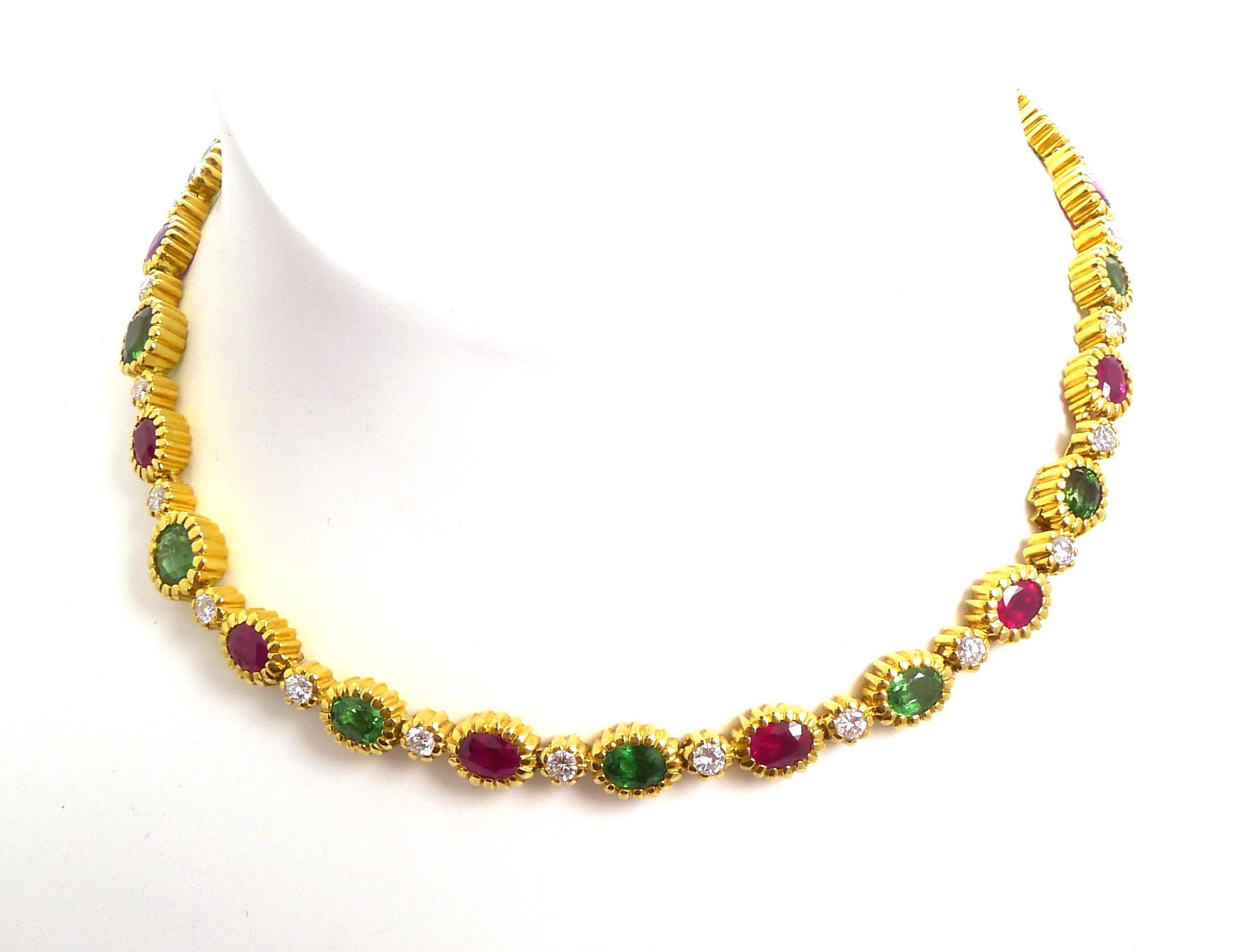The necklace designed as a line of oval-shaped rubies, oval-shaped green garnets and round diamonds, all in reeded gold bezels

The bracelet en suite, designed as a line of oval-shaped rubies, oval-shaped green garnets and round diamonds, all in