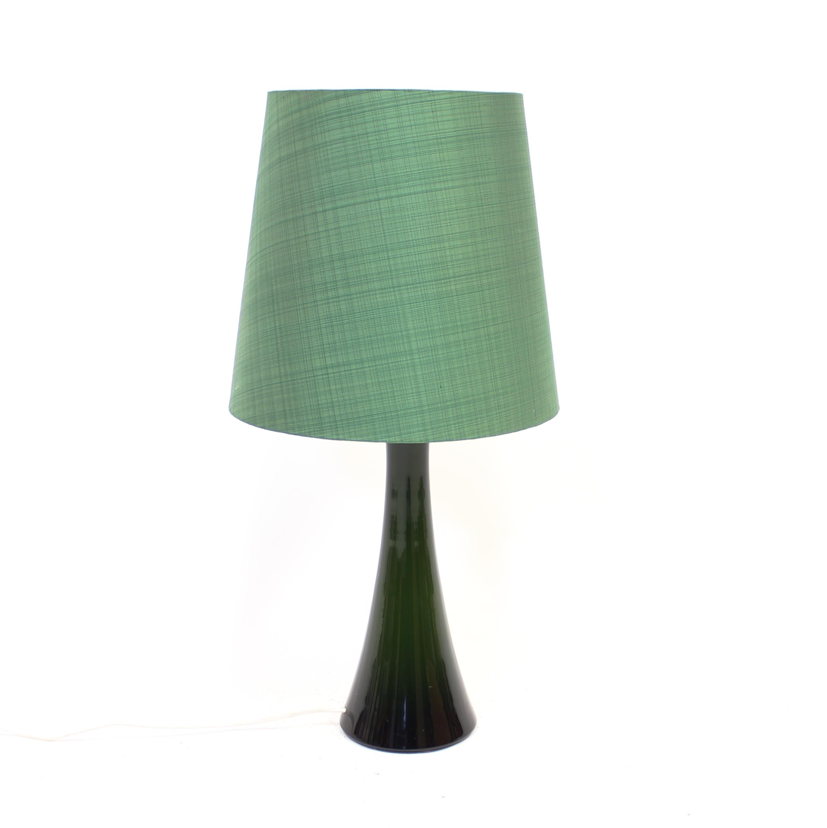 Green glass table lamp with a teak top and green shade by Swedish manufacturer Bergboms. Made in the 1960s. Marked with sticker from manufacturer on the bottom. Very good vintage condition with light ware consistent with age and use.