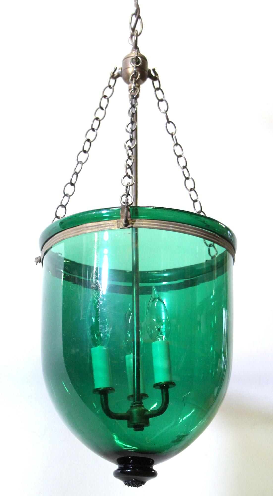 Antique crystal bell jar pendant light with a deep green hue and brass hardware. The brass hardware includes the chain, canopy, rod, and finial which supports the hand-blown glass jar and 3-lights. Price includes the cleaning, and wiring. 

