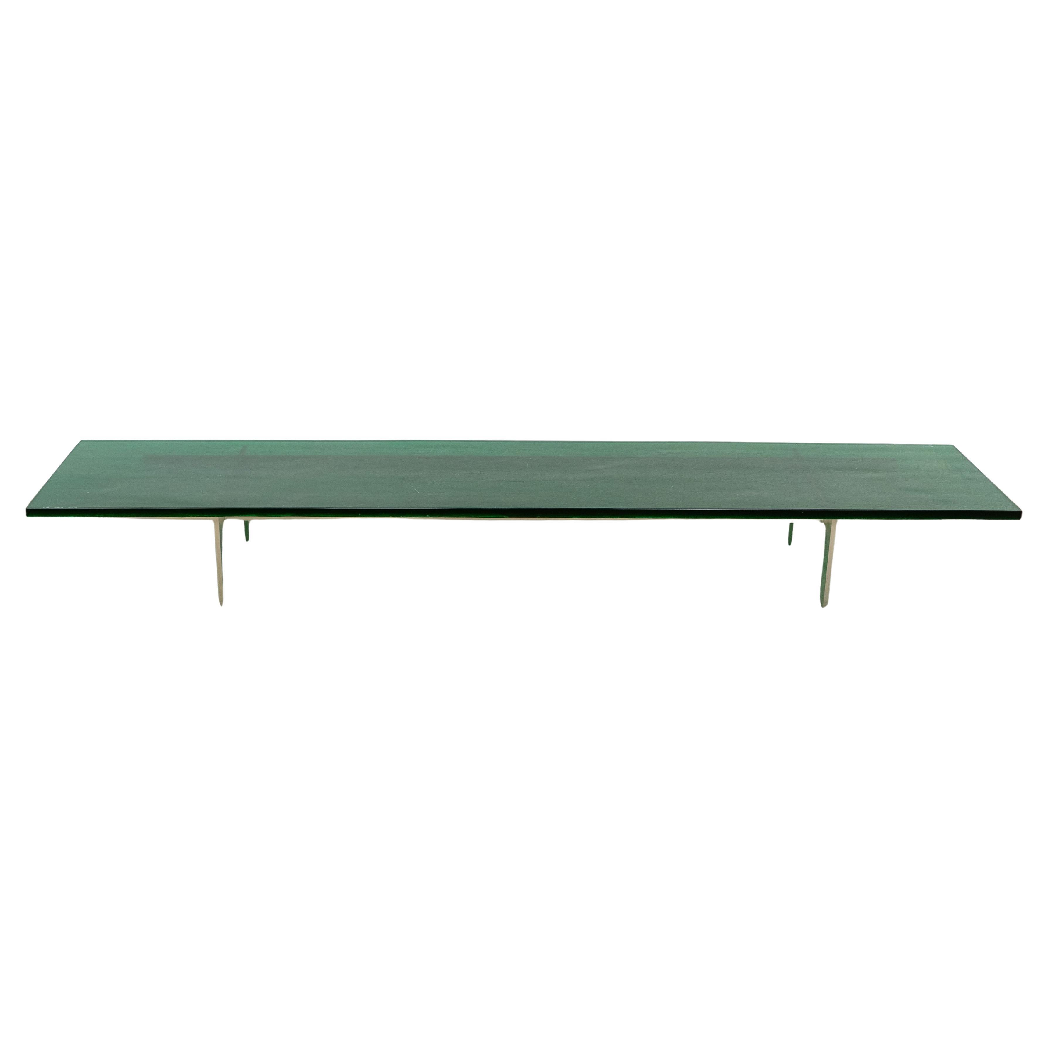 Table basse à plateau en verre vert avec base en acier.