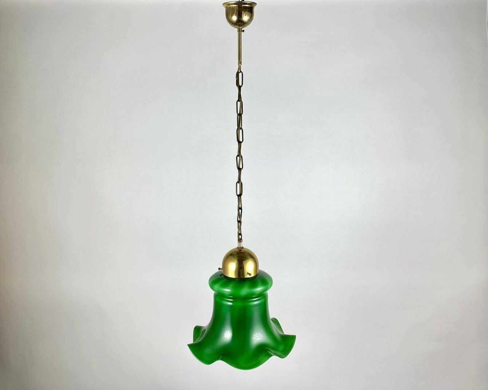 Pendentif en verre vert et laiton doré fabriqué en Belgique, vers les années 1980.

 Cette lampe suspendue élégante et stylée est une solution d'intérieur fonctionnelle. Les parties métalliques de la lampe sont en laiton avec dorure. L'abat-jour a